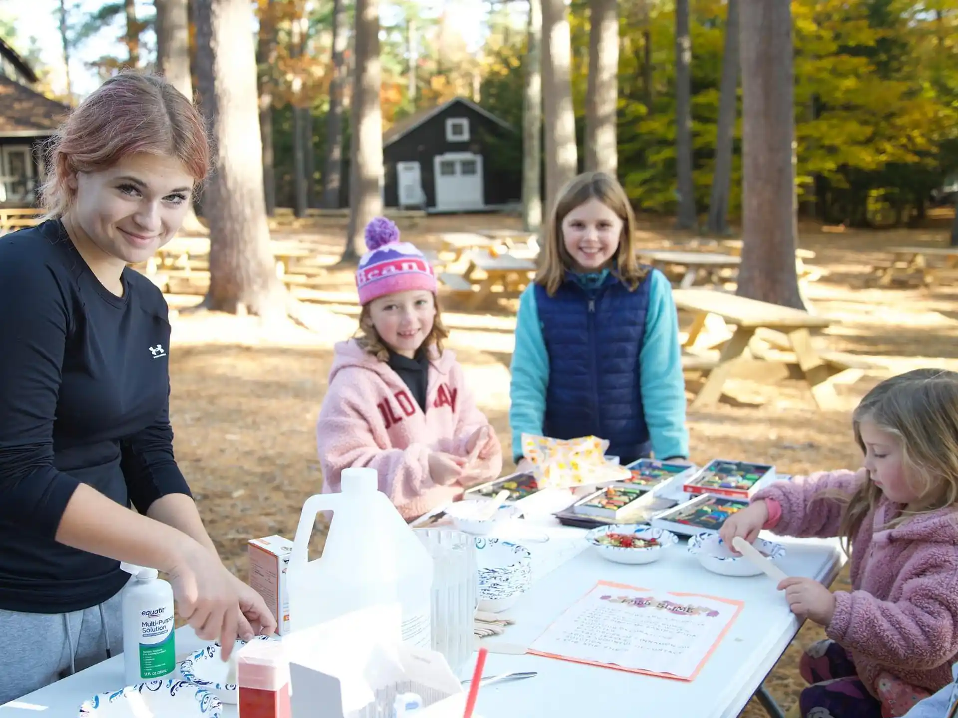 a group of children sitting around a table outside