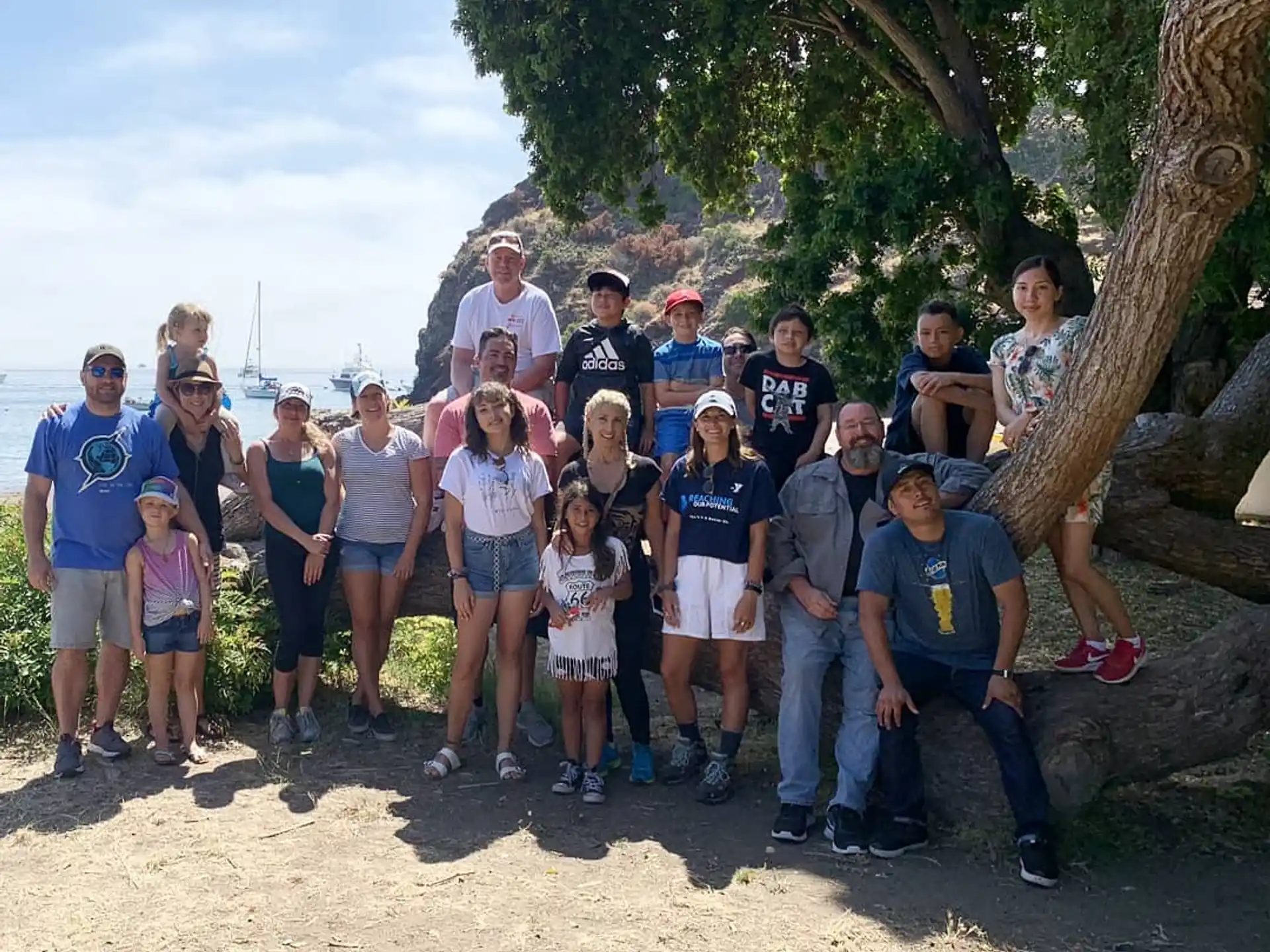 a group of people posing for a photo under a tree