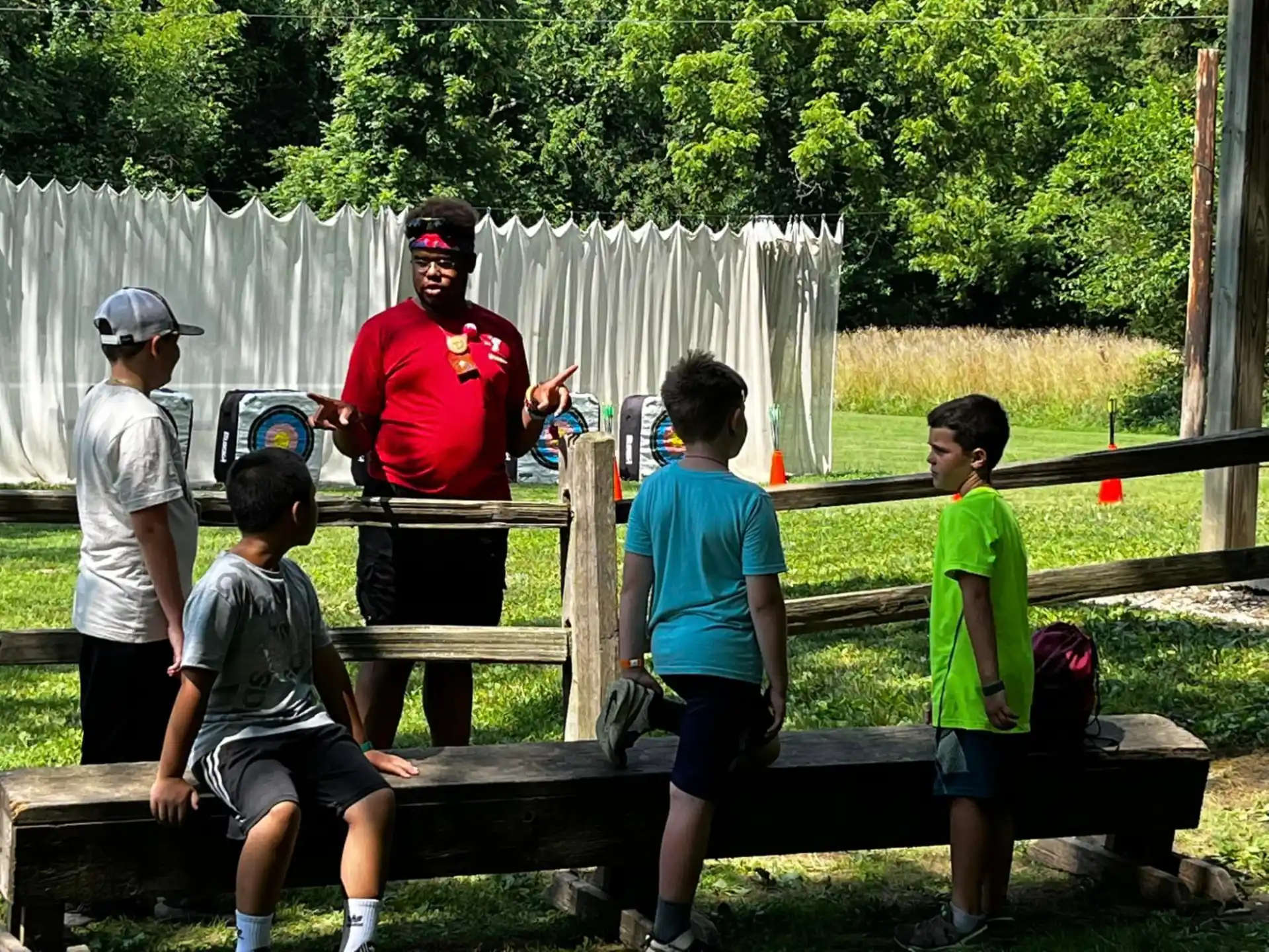 a group of people standing around a wooden bench