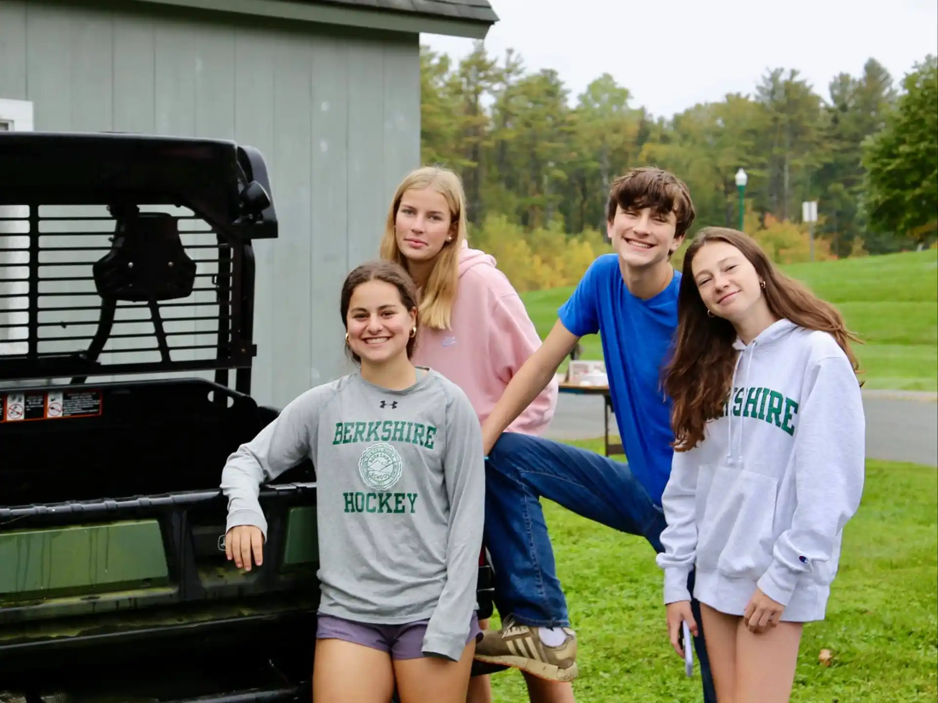 a group of people posing for a photo in front of a car