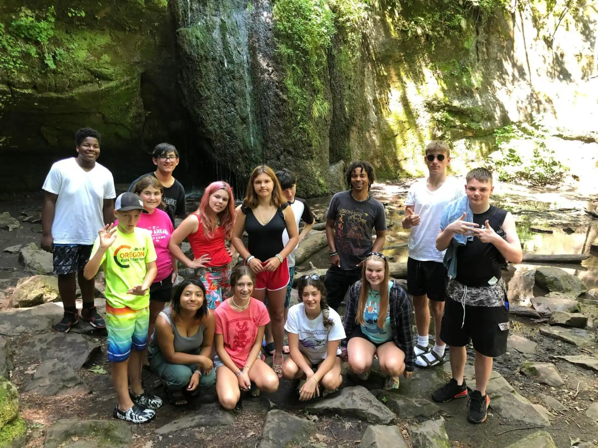a group of people posing for a photo in front of a rocky cliff