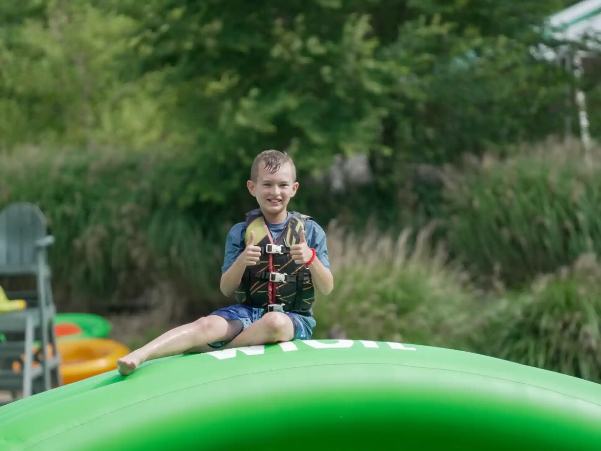 a boy sitting on a green raft