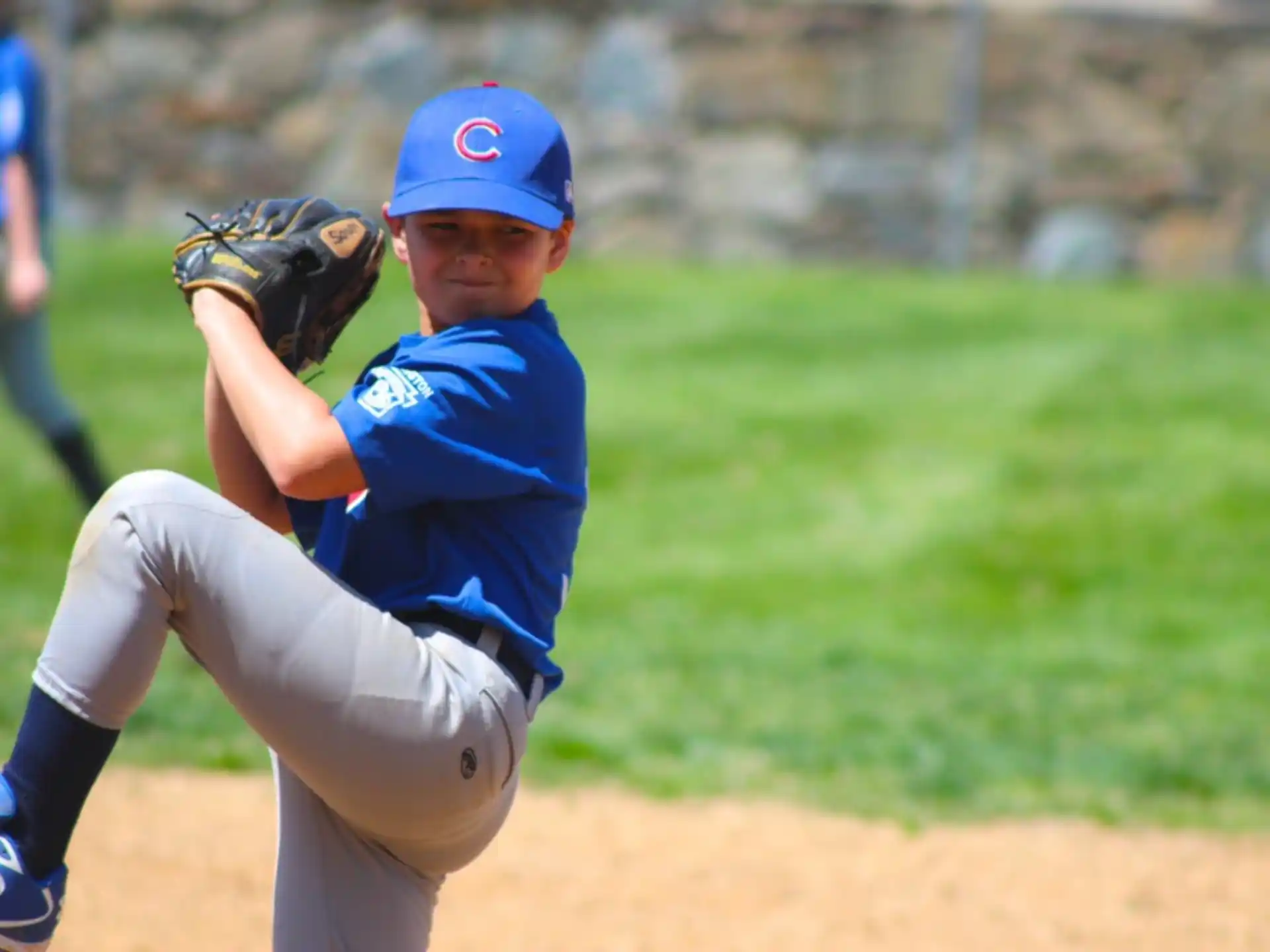 a young boy pitching a baseball