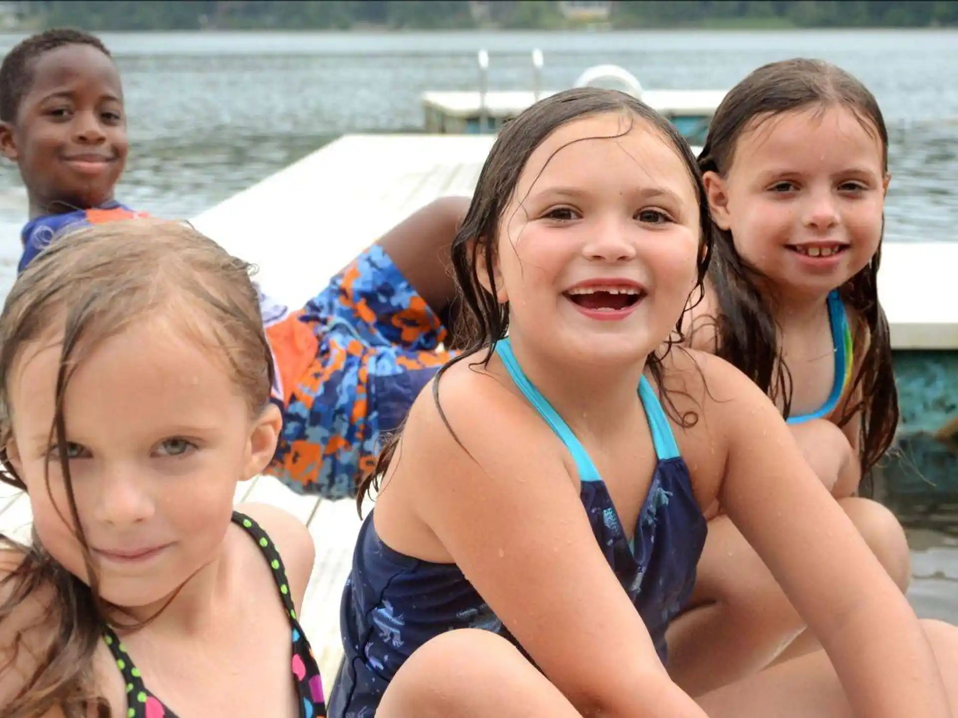 a group of children in swimsuits on a boat