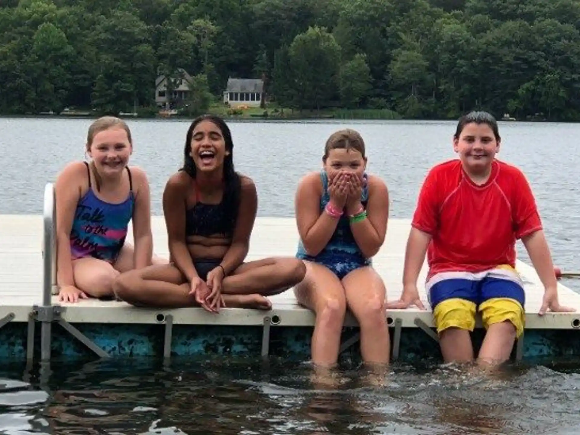 a group of people sitting on a dock in the water