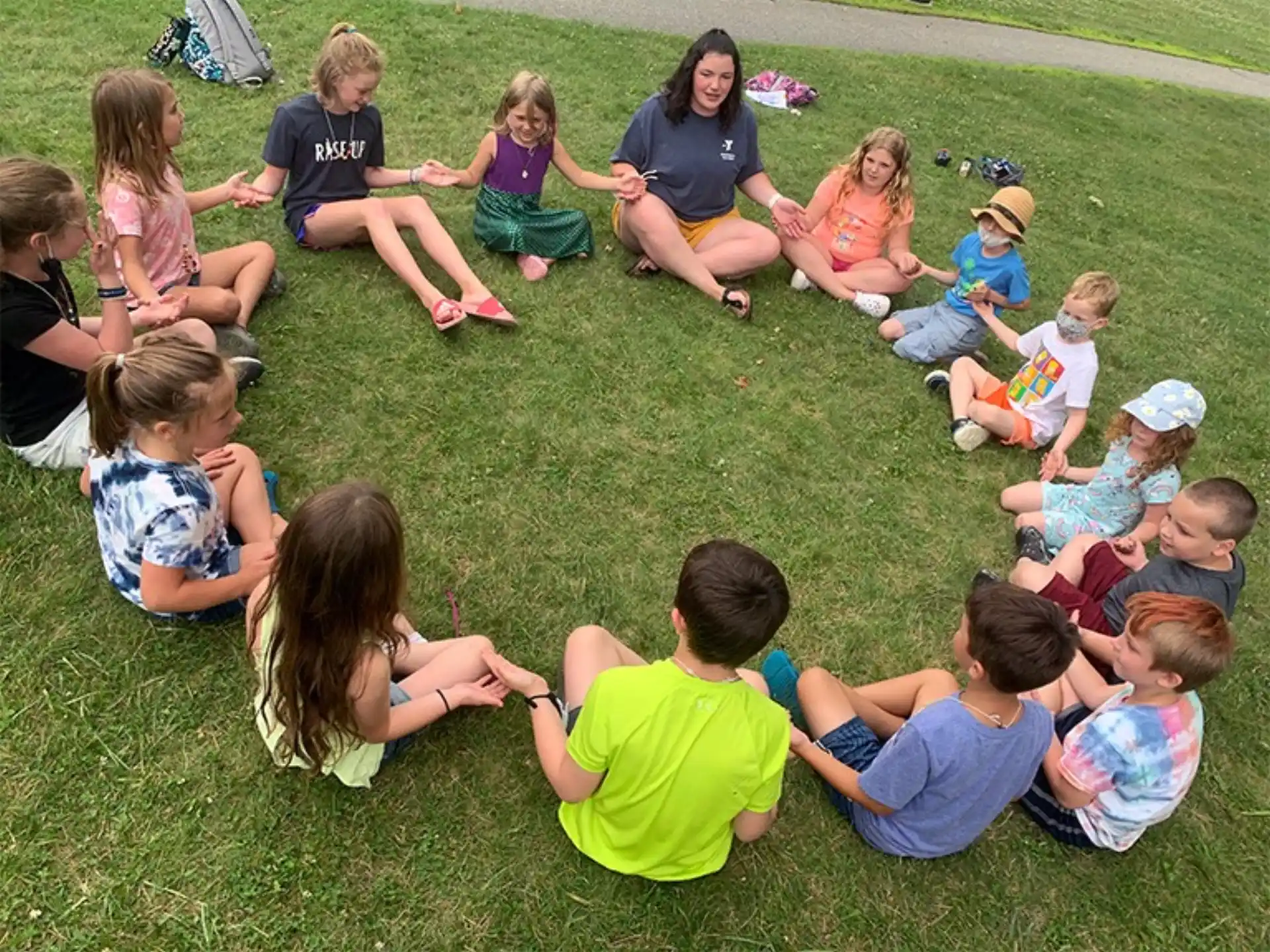 a group of children sitting on the grass