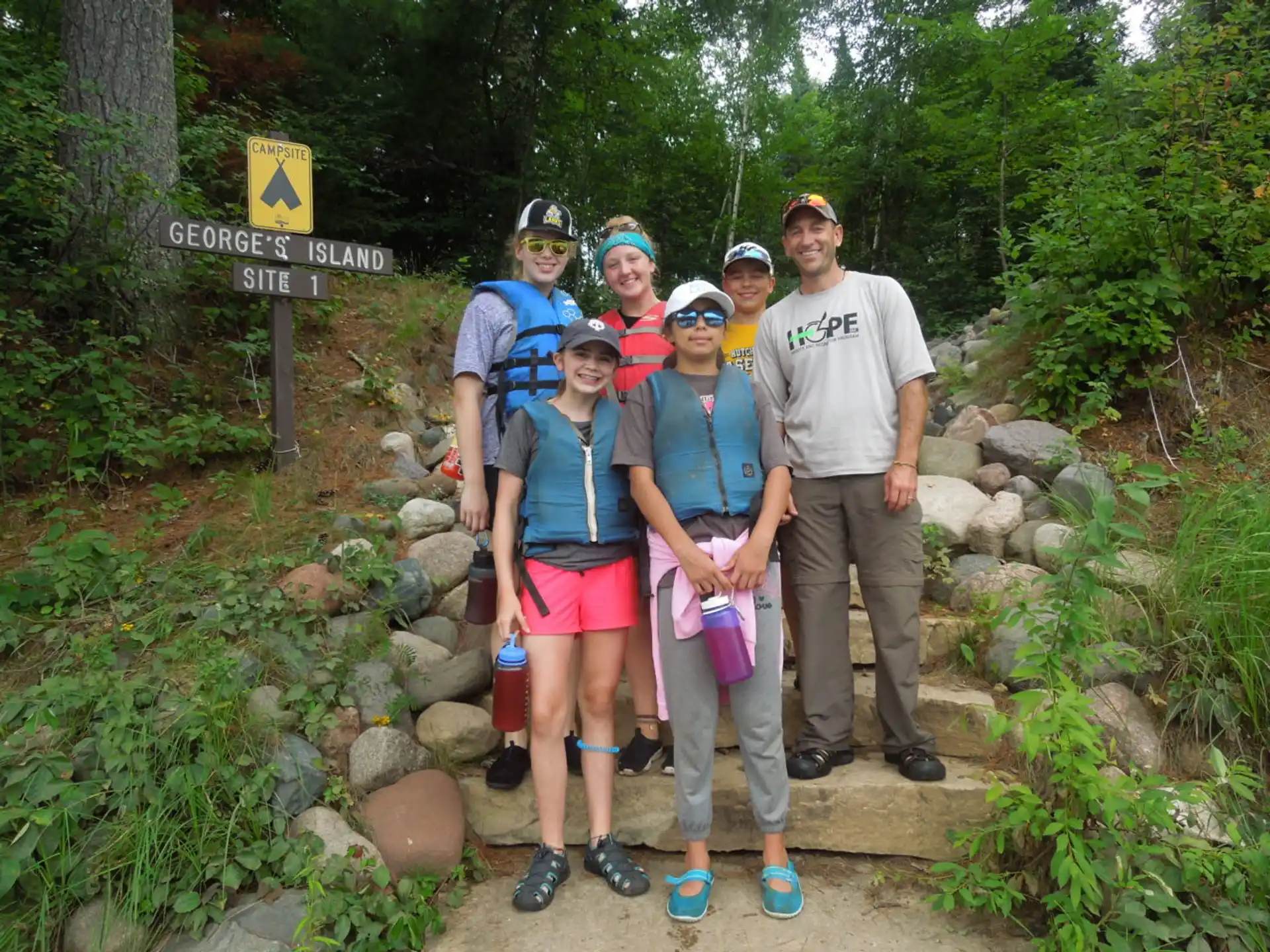 a group of people posing for a photo in front of a sign