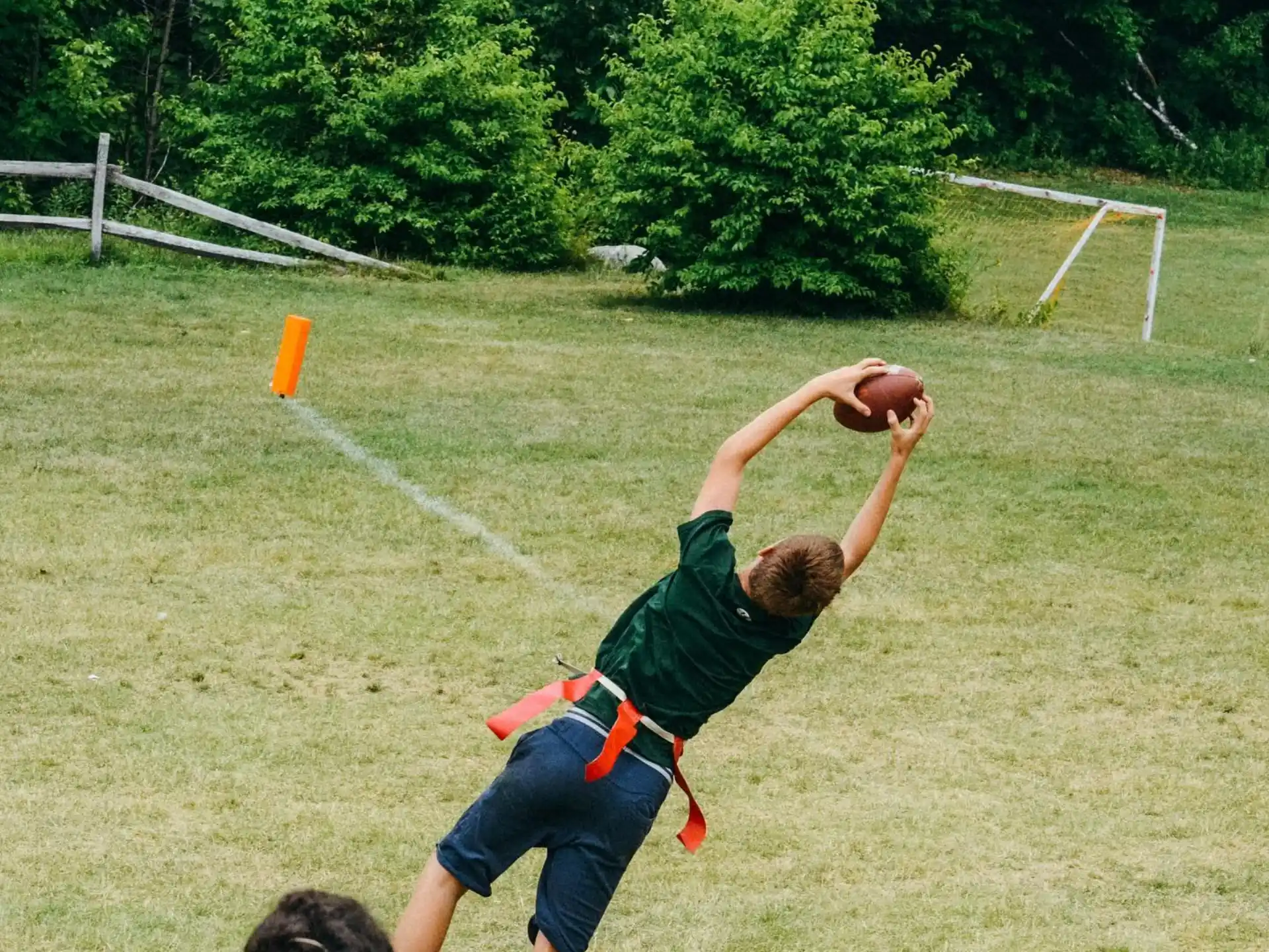 a boy doing a handstand on a field