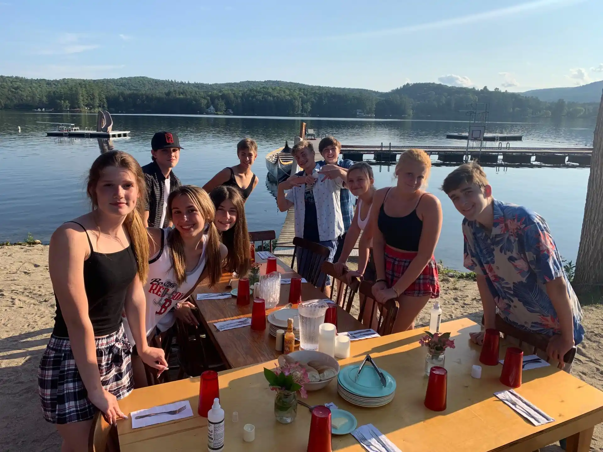 a group of people posing for a photo by a table with food