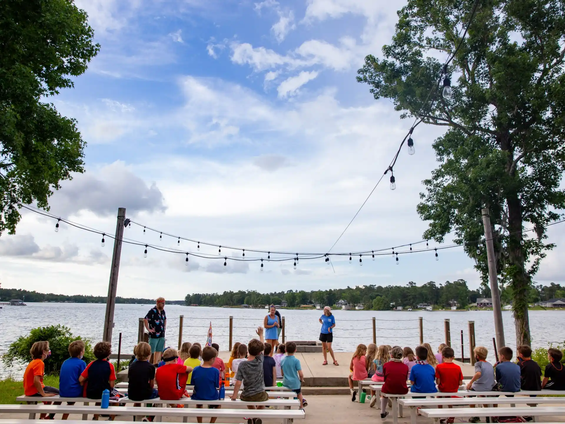 a group of people sitting on a bench by a body of water