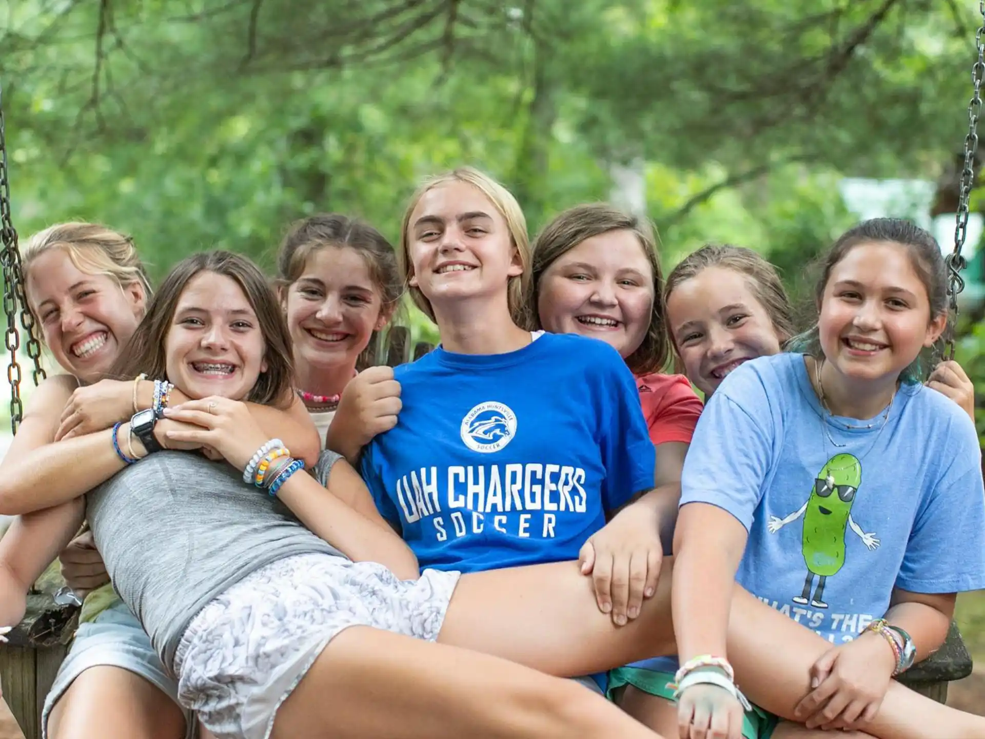 a group of girls sitting together smiling