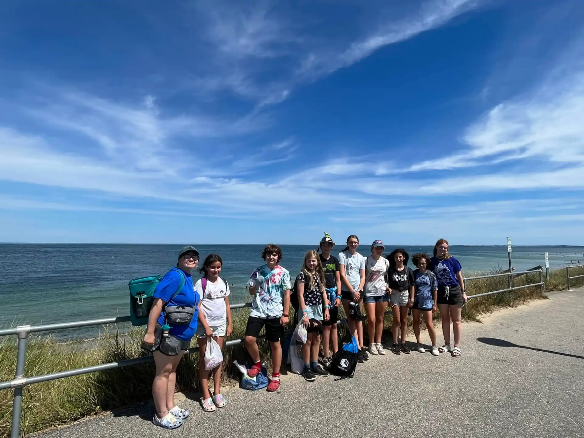 a group of people posing for a photo on a path by the water
