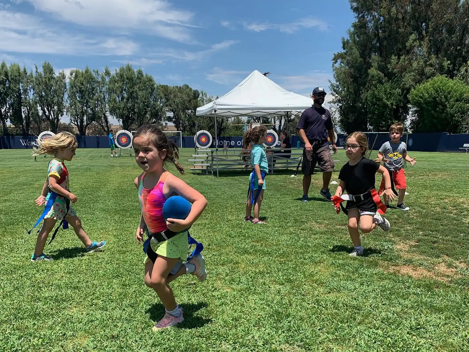a group of kids running in a field