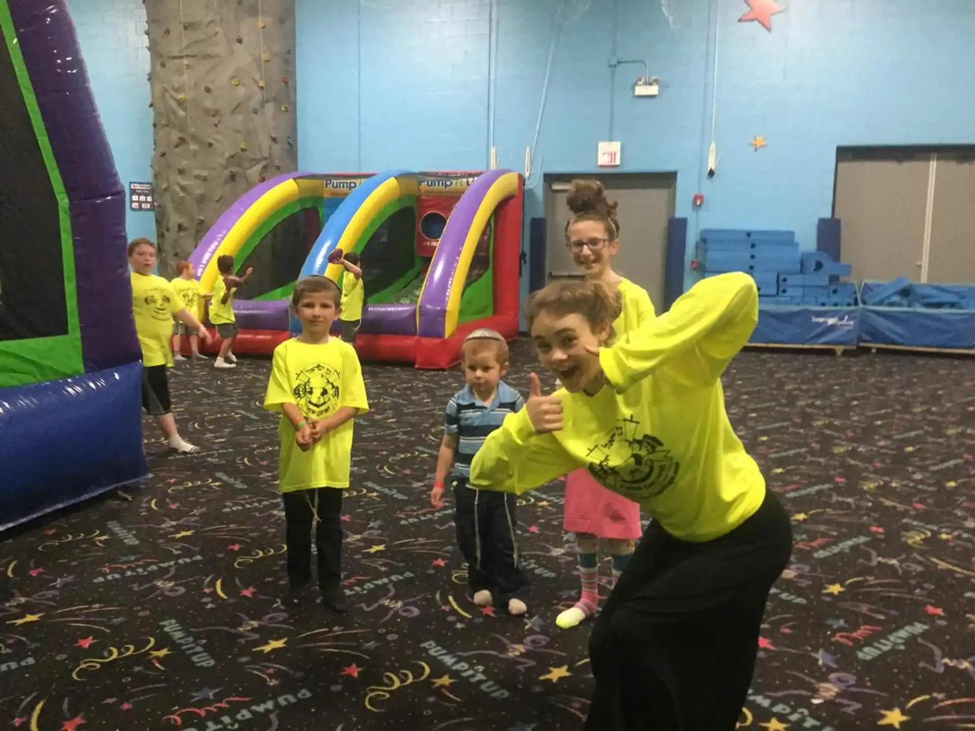 a group of children playing in a room with a large slide