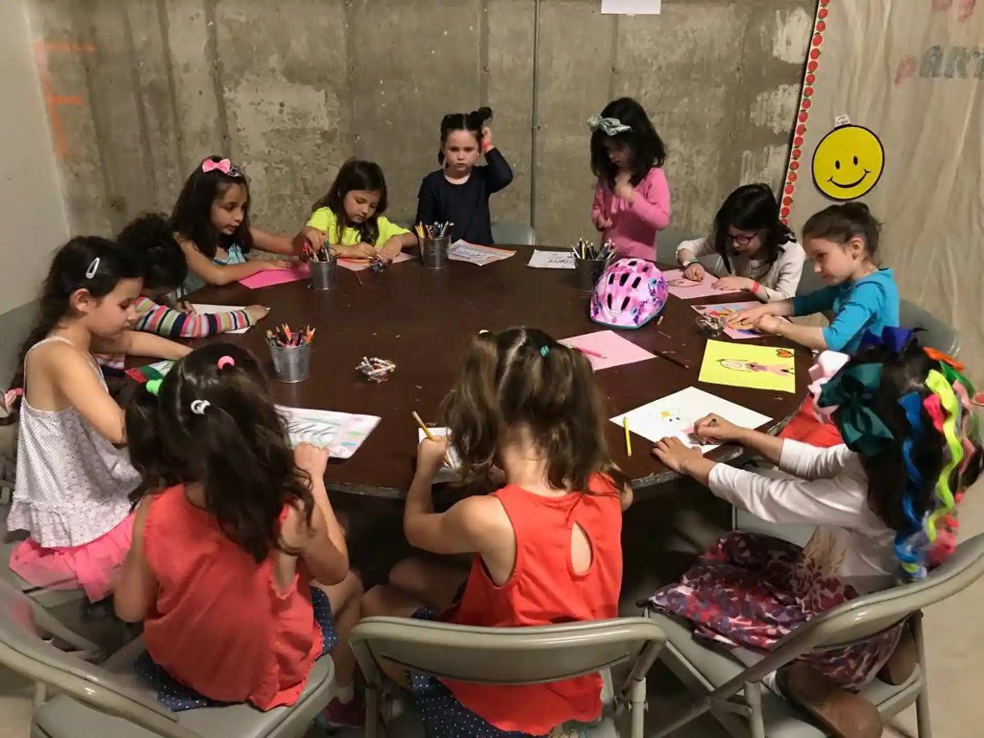 a group of children sitting around a table