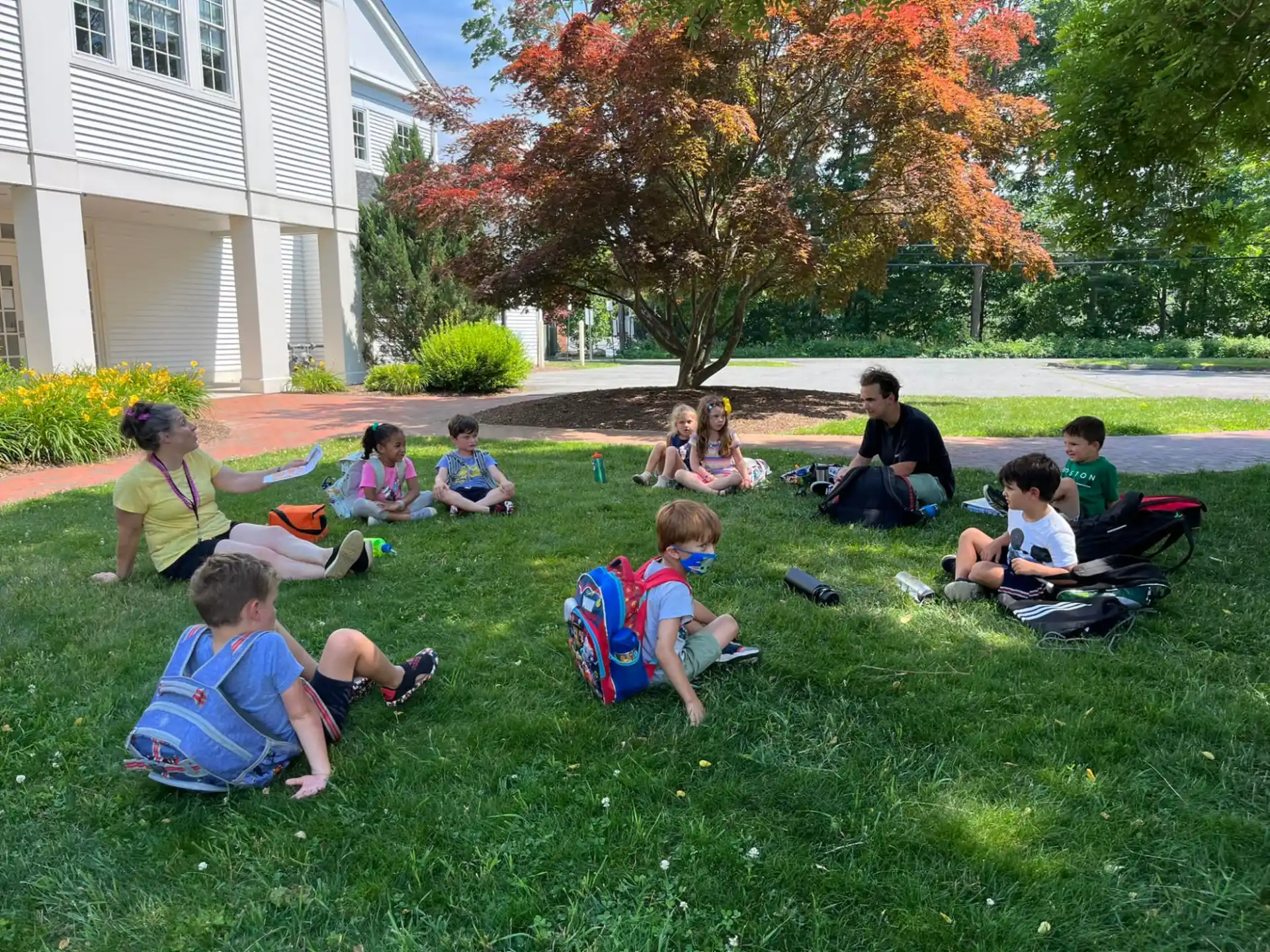 a group of children sitting on the grass