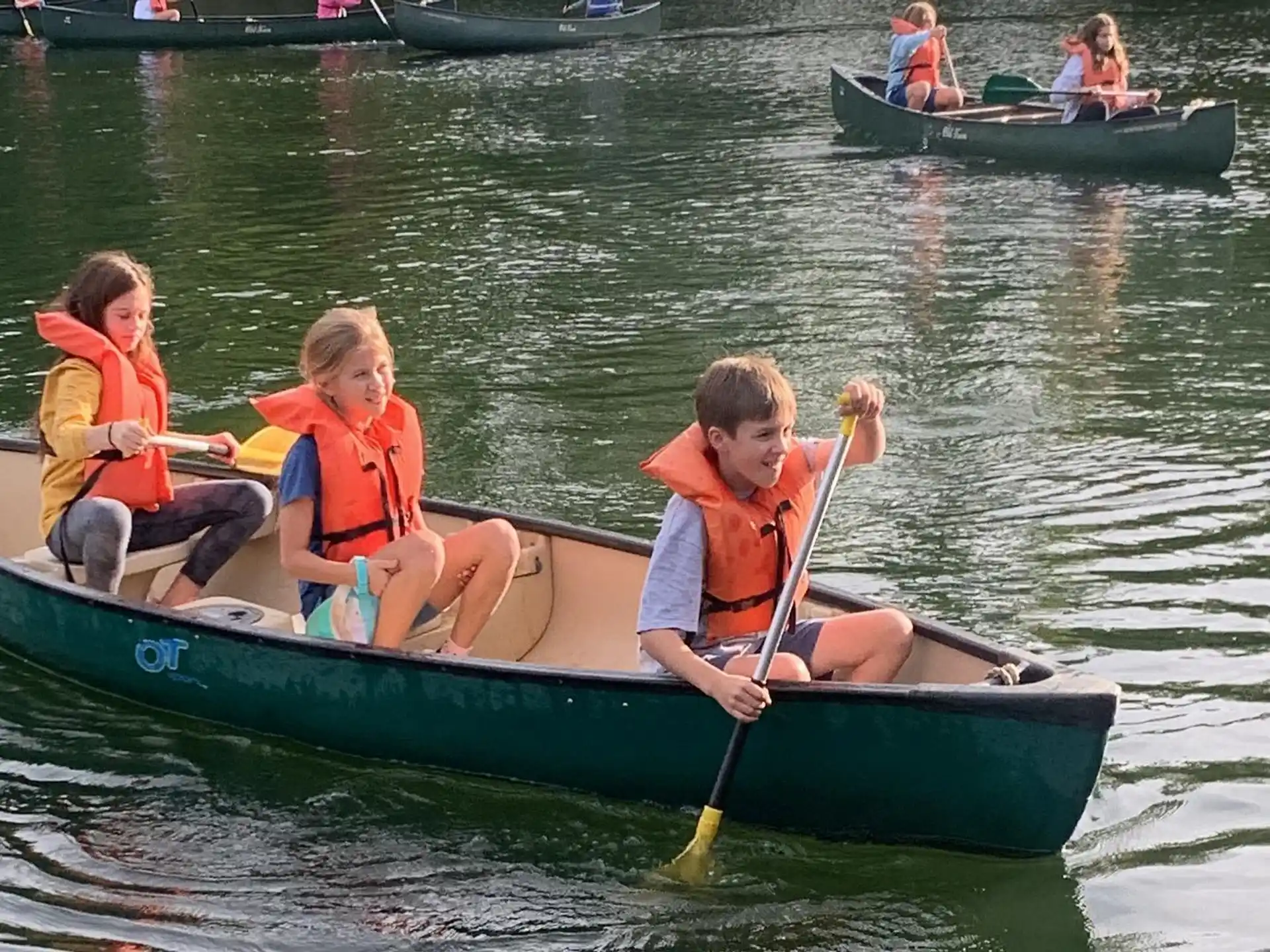 a group of kids in a canoe