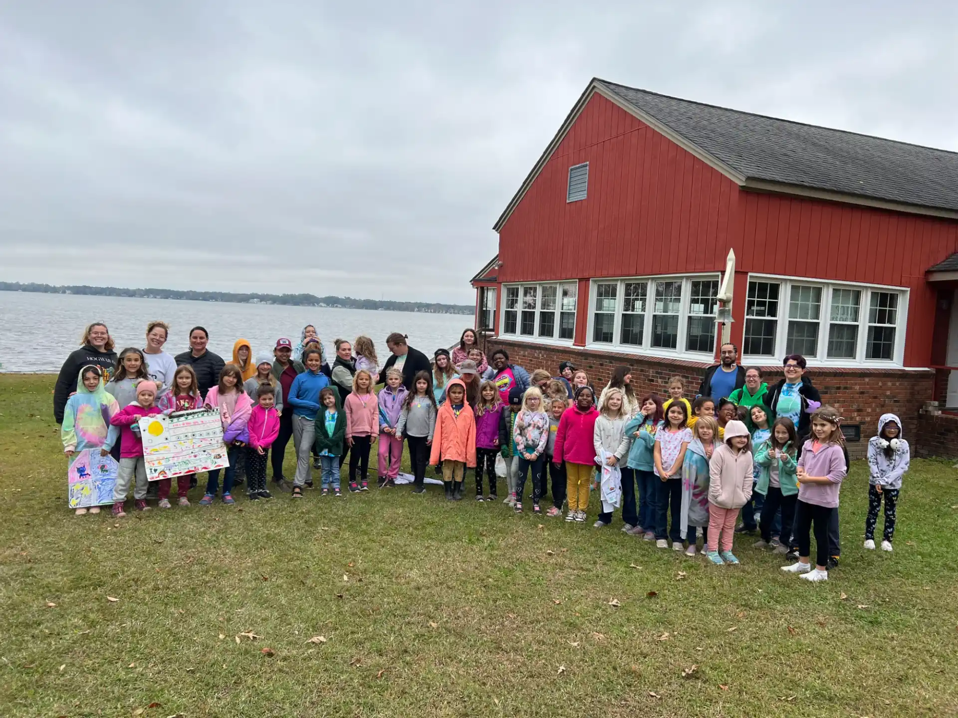 a group of children posing for a photo in front of a house
