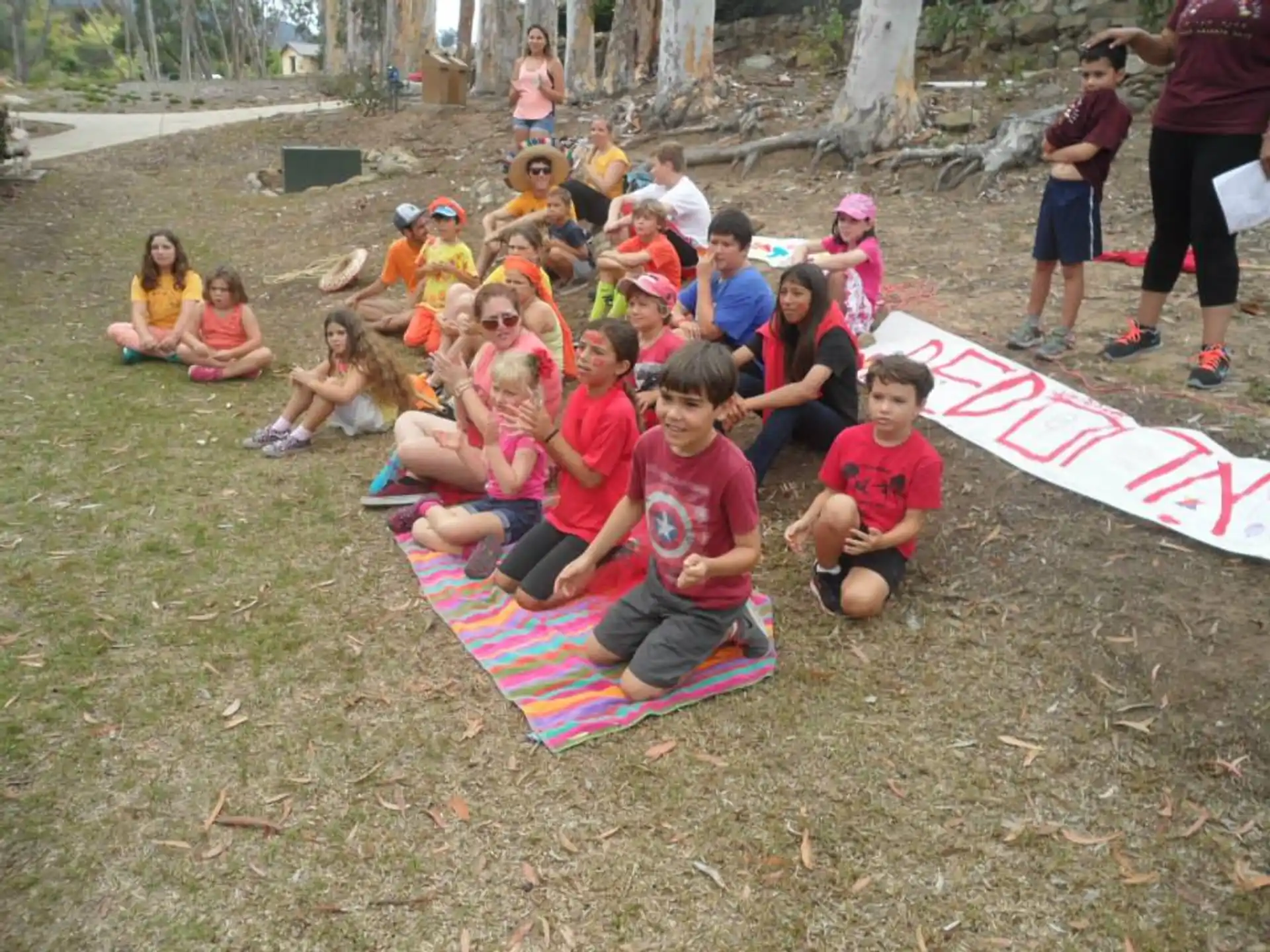 a group of children sitting on the ground with a flag