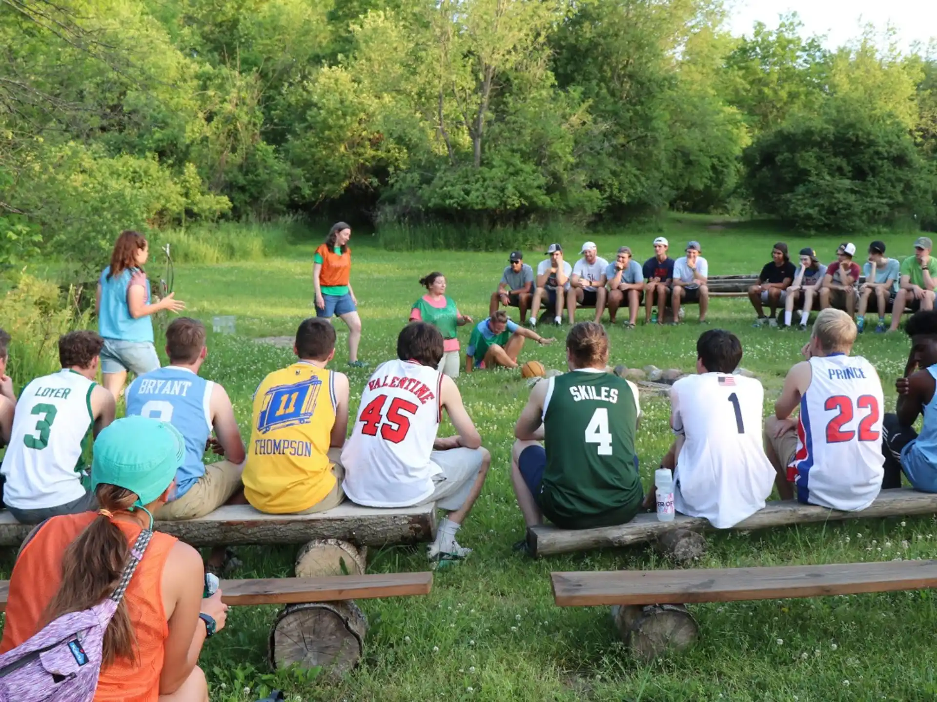 a group of people sitting on picnic tables in a park