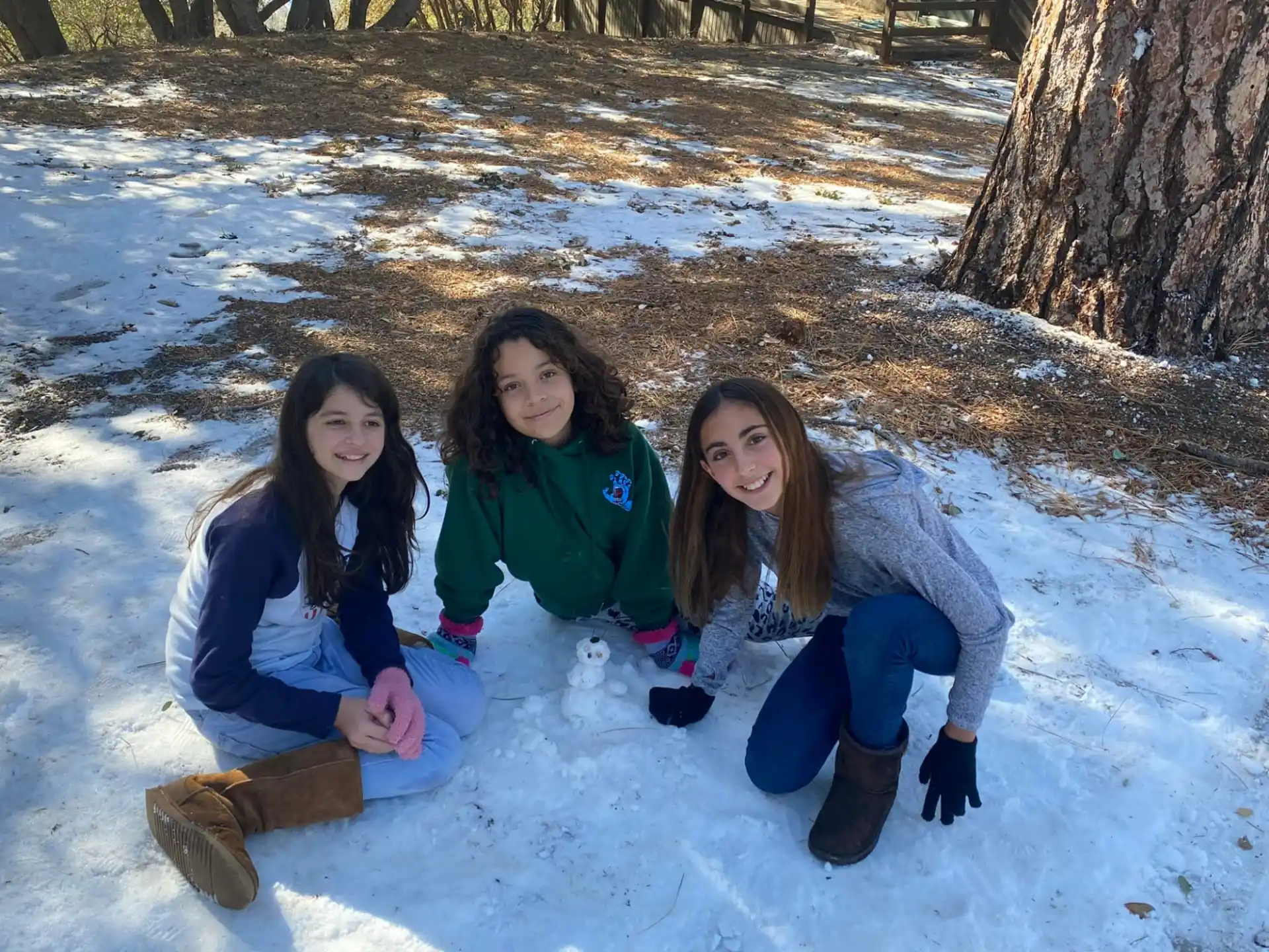 a group of girls sitting in the snow