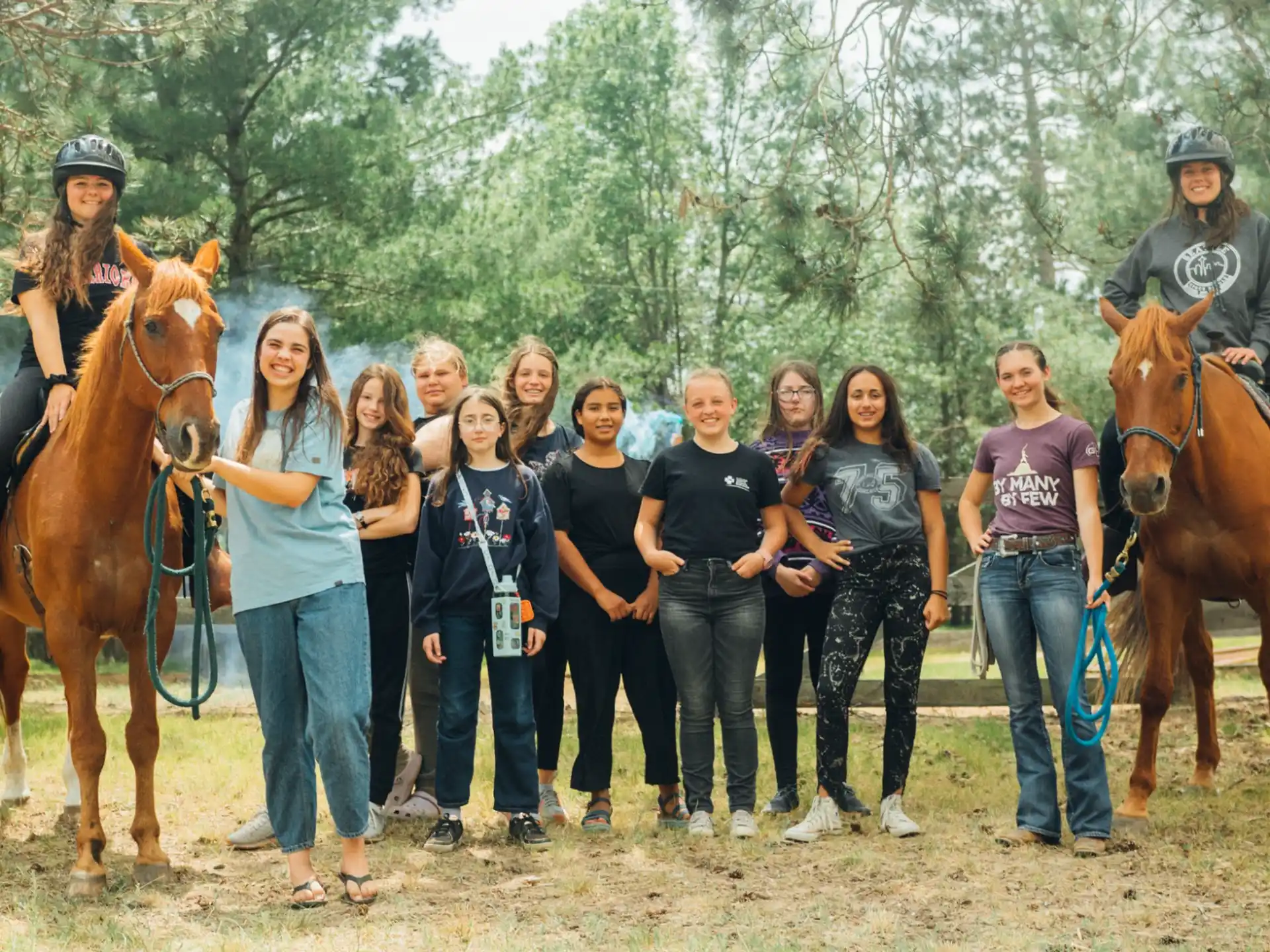 a group of people posing with horses