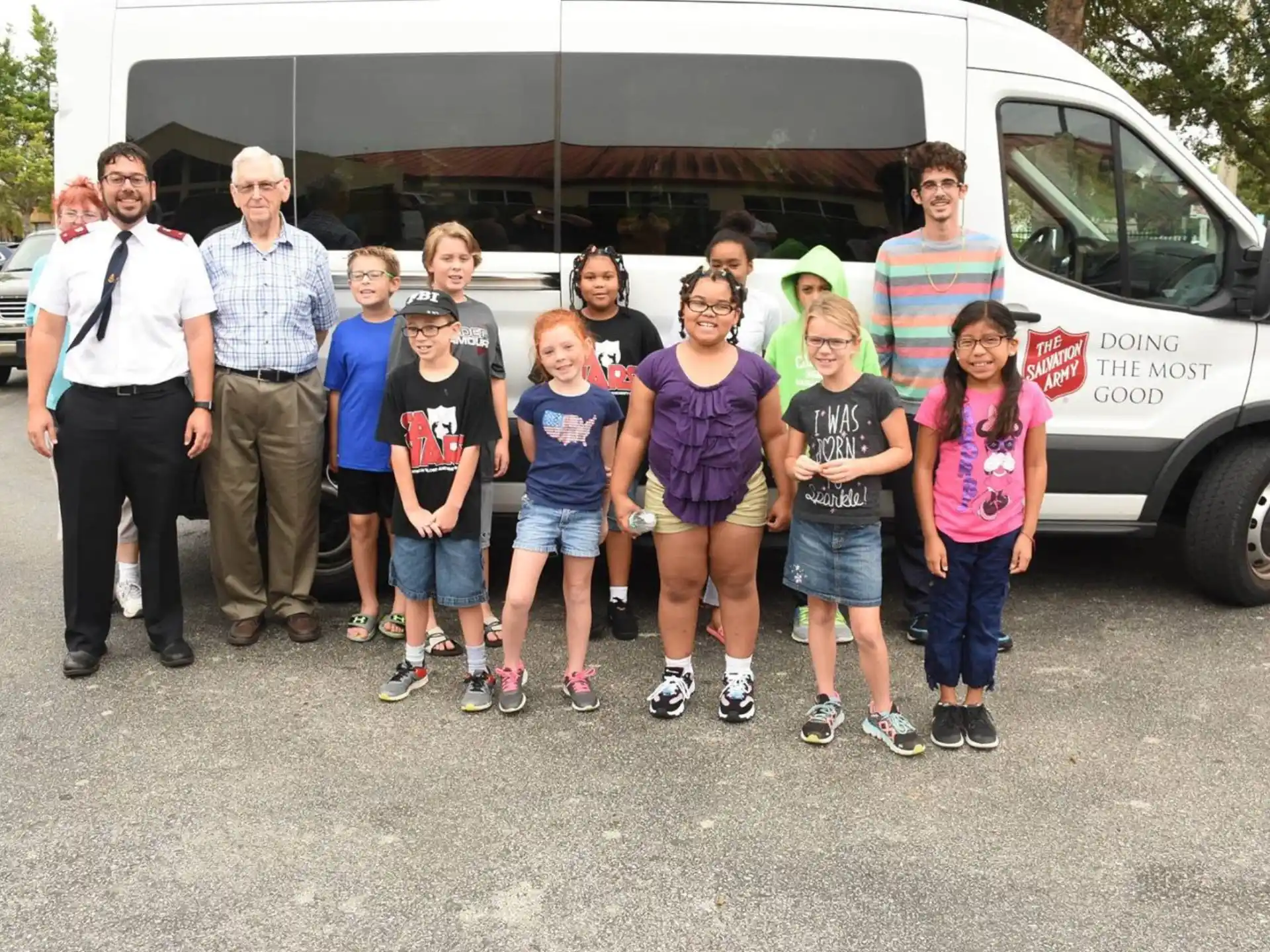 a group of people posing for a photo in front of a bus