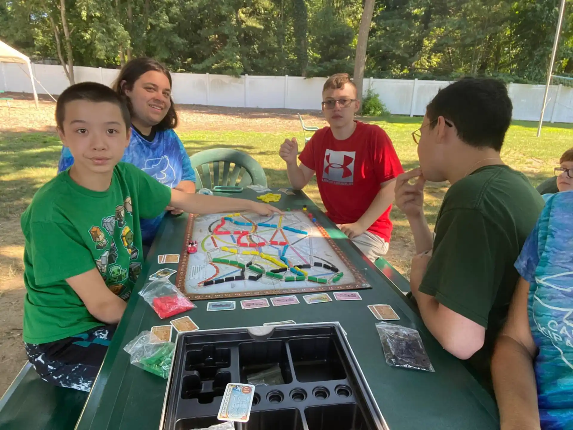 a group of people sitting at a table with a board game