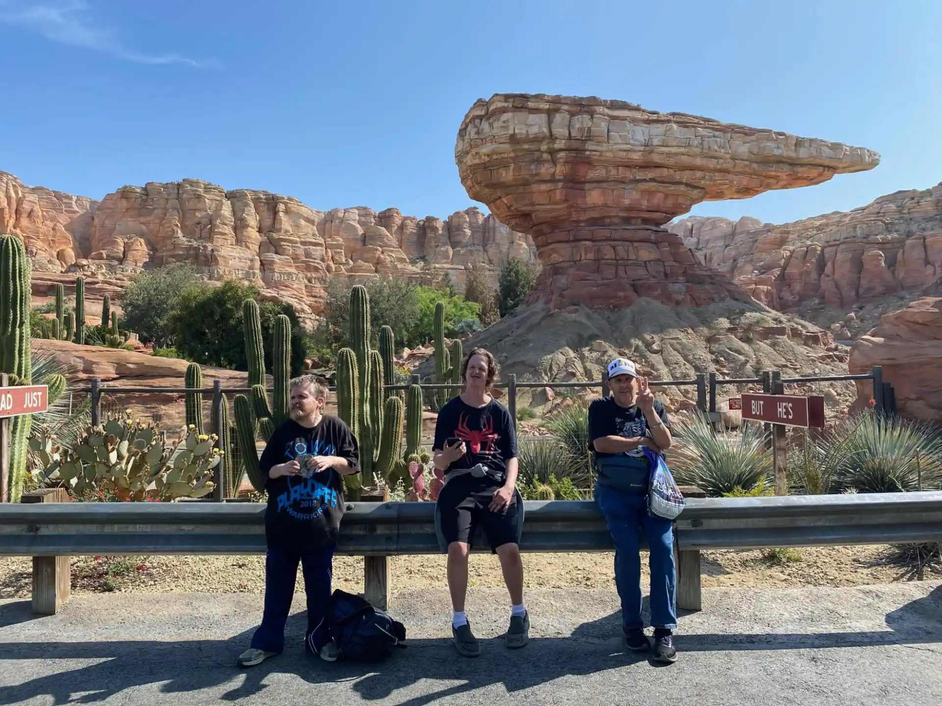 a group of people posing for a photo in front of a rock formation