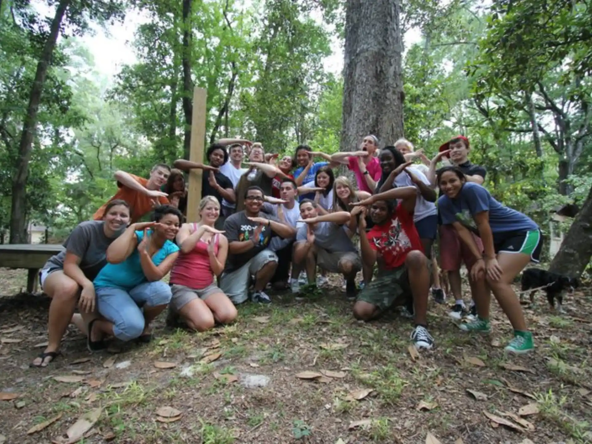 a group of people posing for a photo in the woods