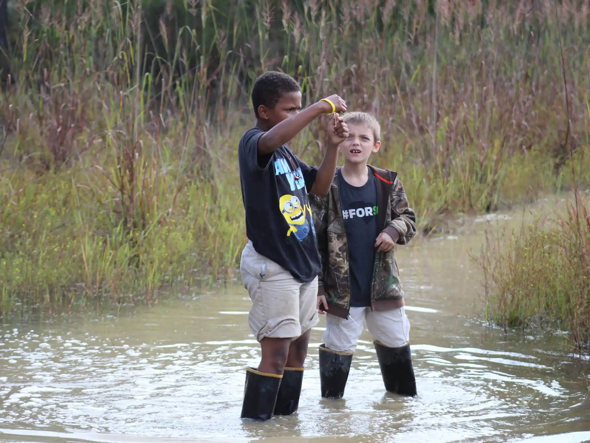 two boys standing in water