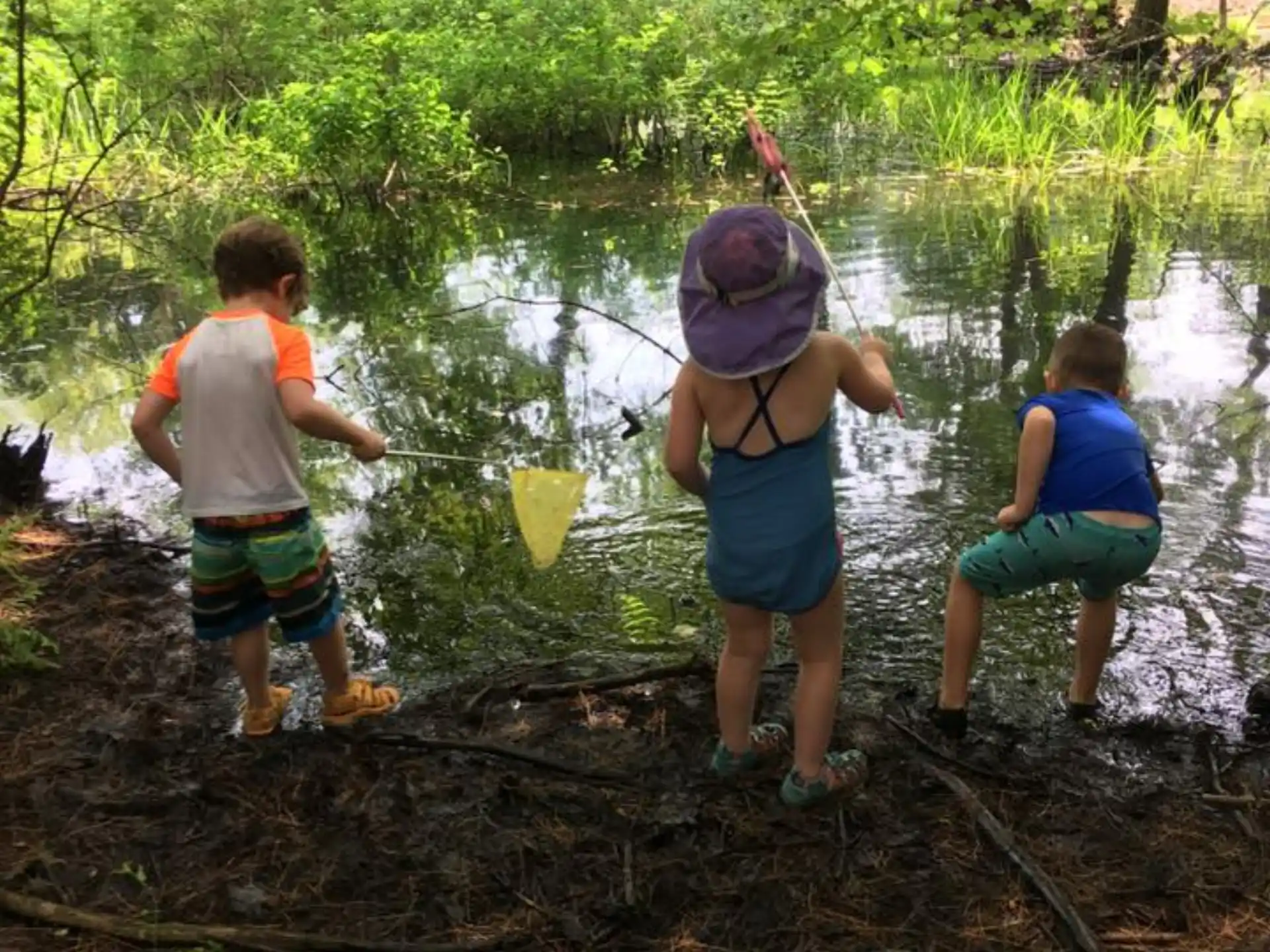 a group of children standing in a river