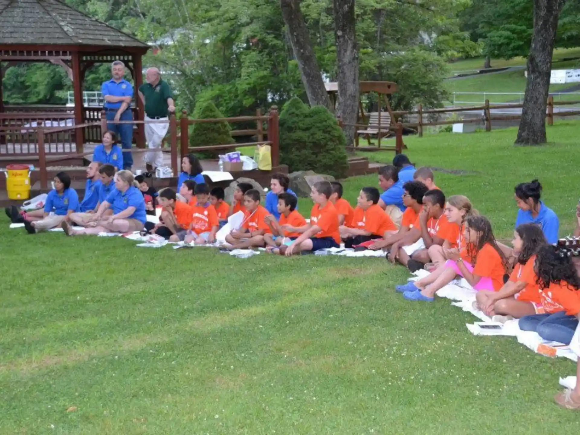 a group of people sitting on the grass
