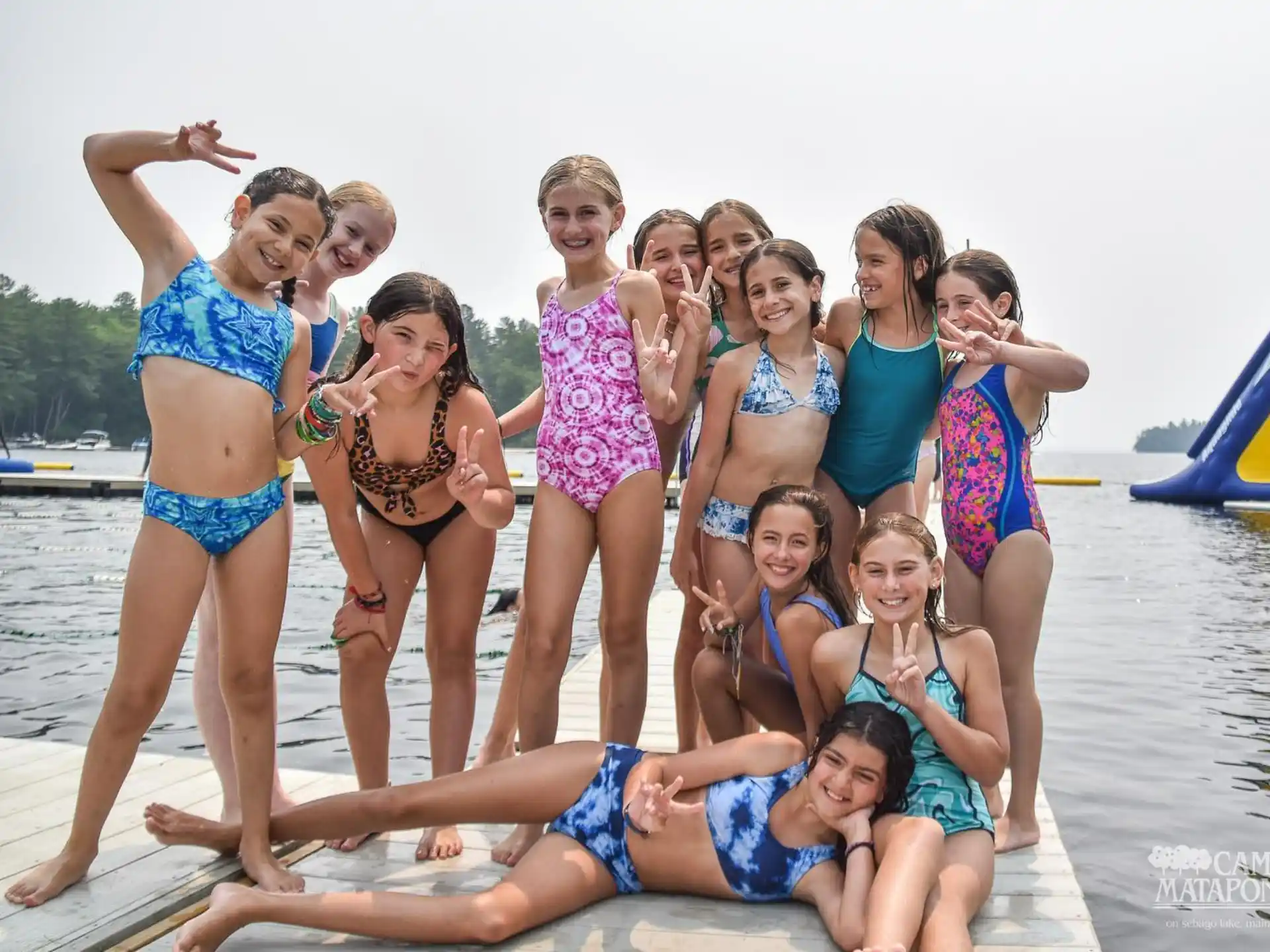 a group of women posing for a photo on a beach