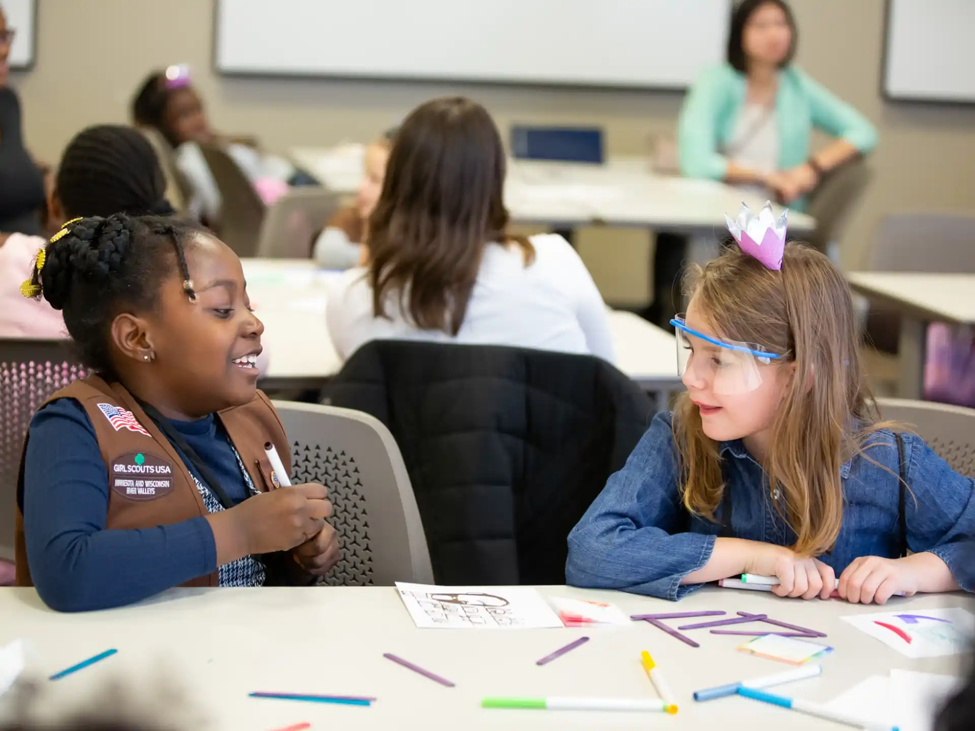 a few young girls sitting at a table