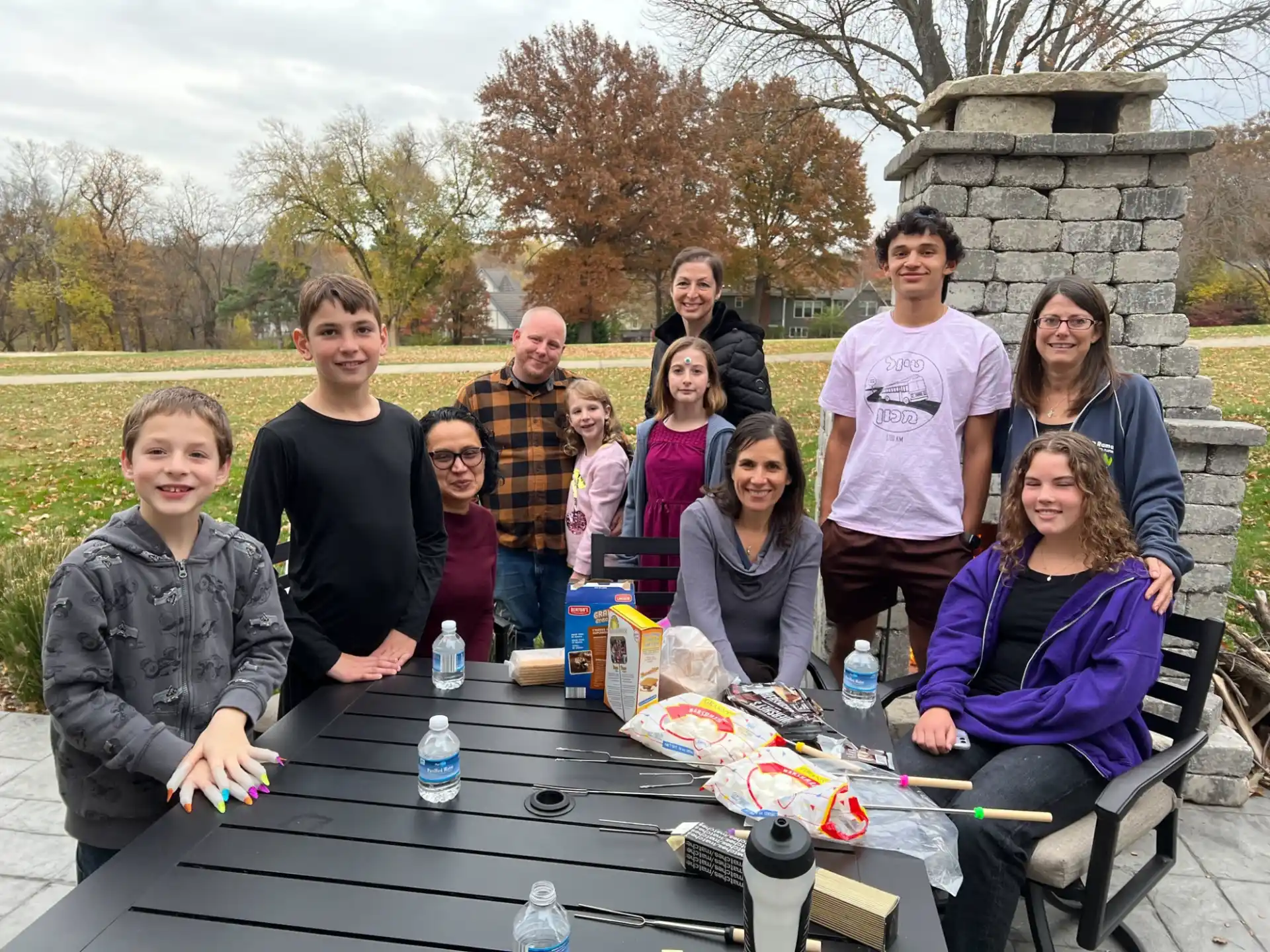 a group of people standing around a table outside