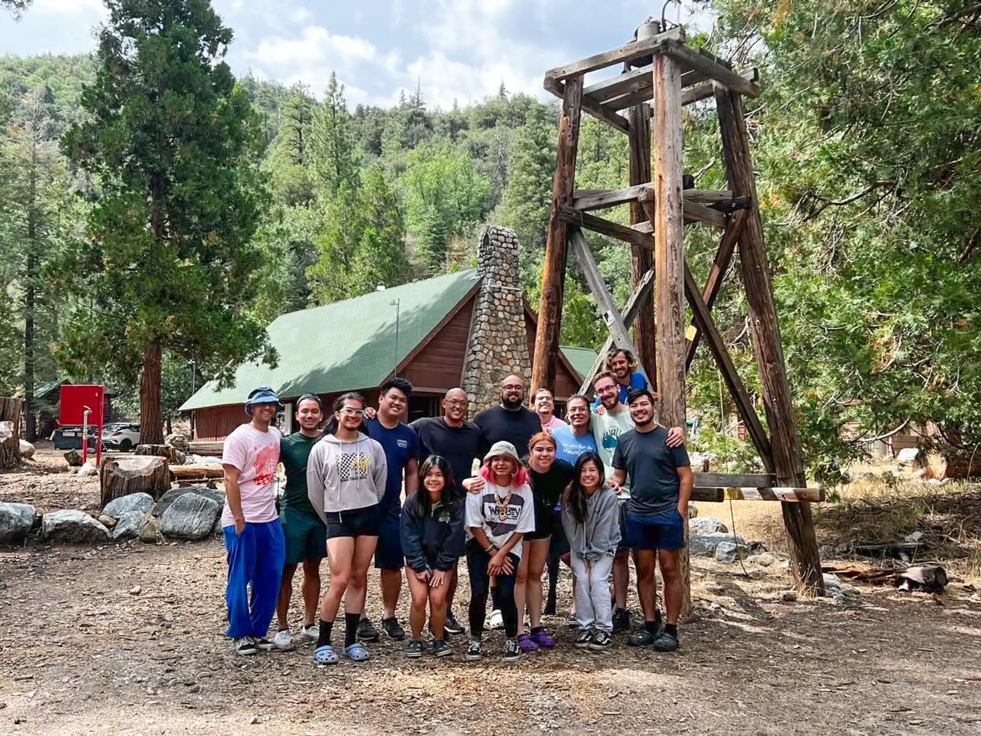 a group of people posing for a photo in front of a wooden structure