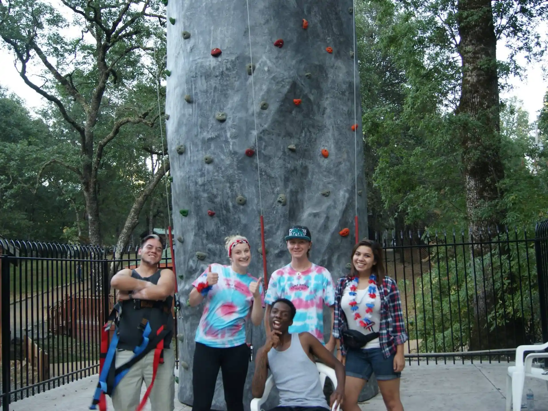a group of people posing for a photo next to a rock