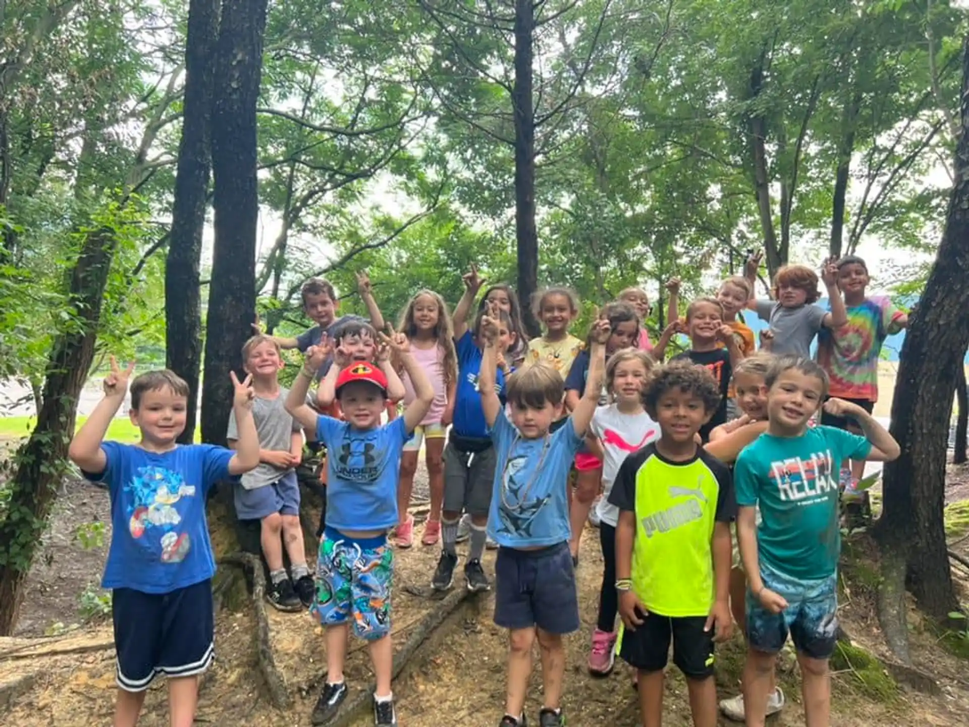 a group of kids posing for a photo in the woods
