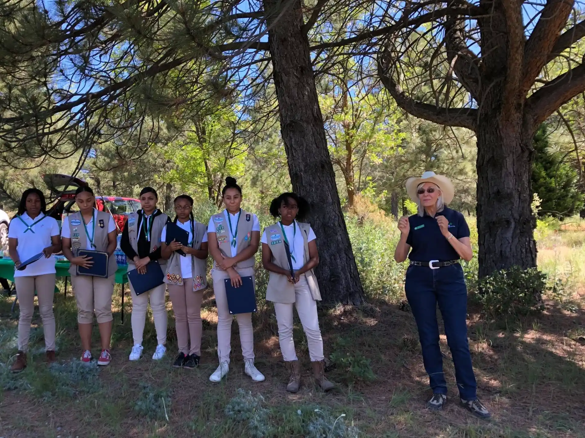 a group of people standing in a line under trees