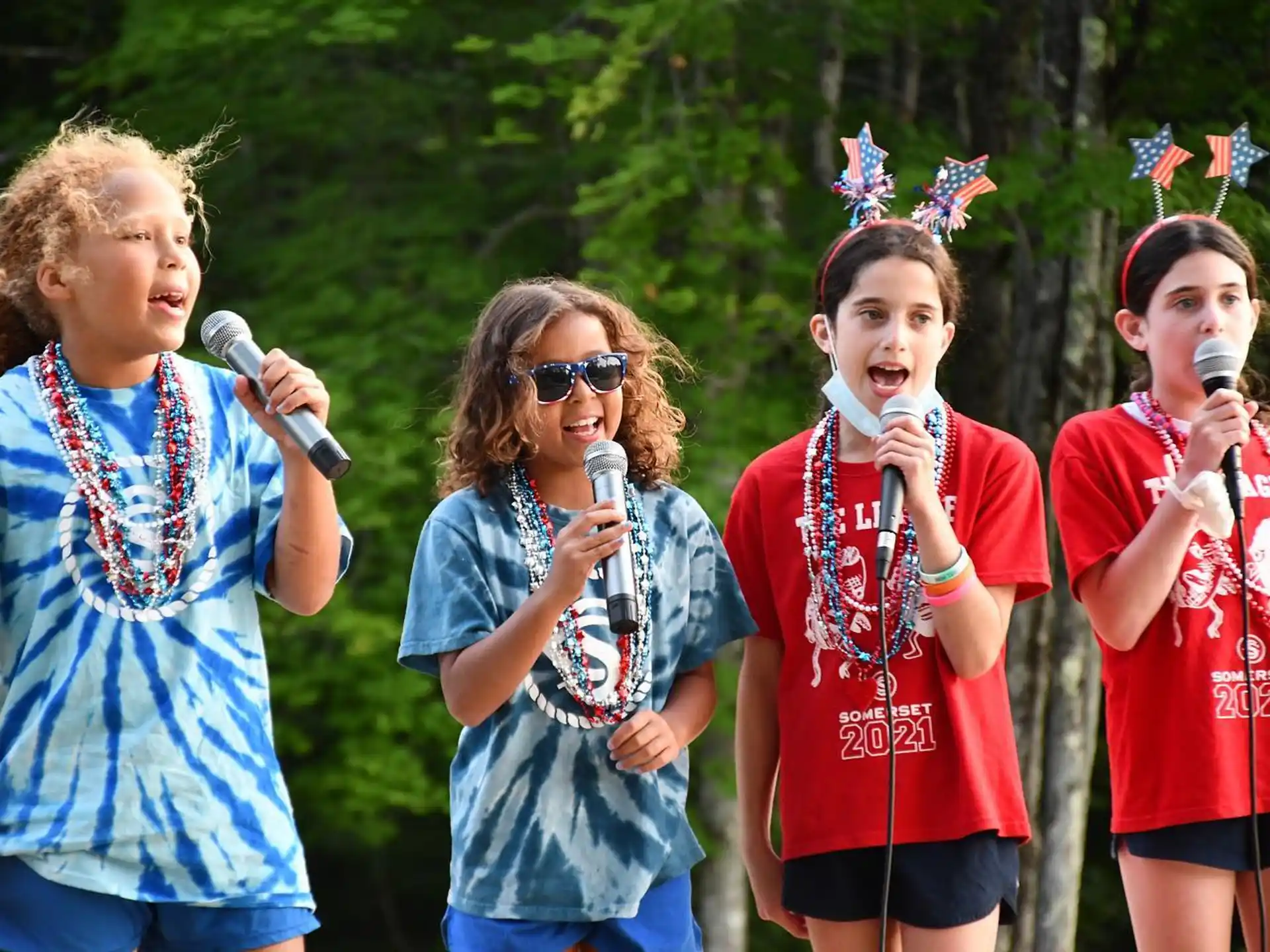 a group of people singing into microphones