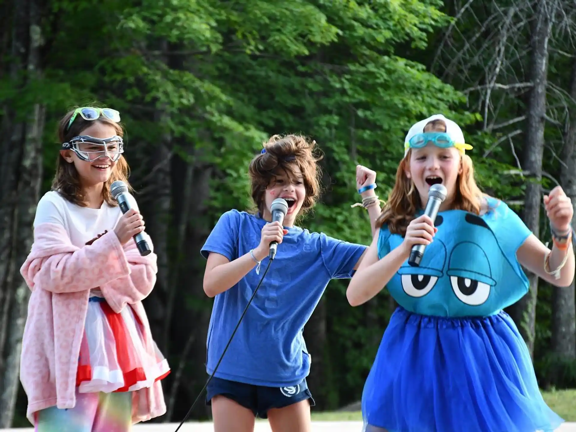 a group of women singing into microphones