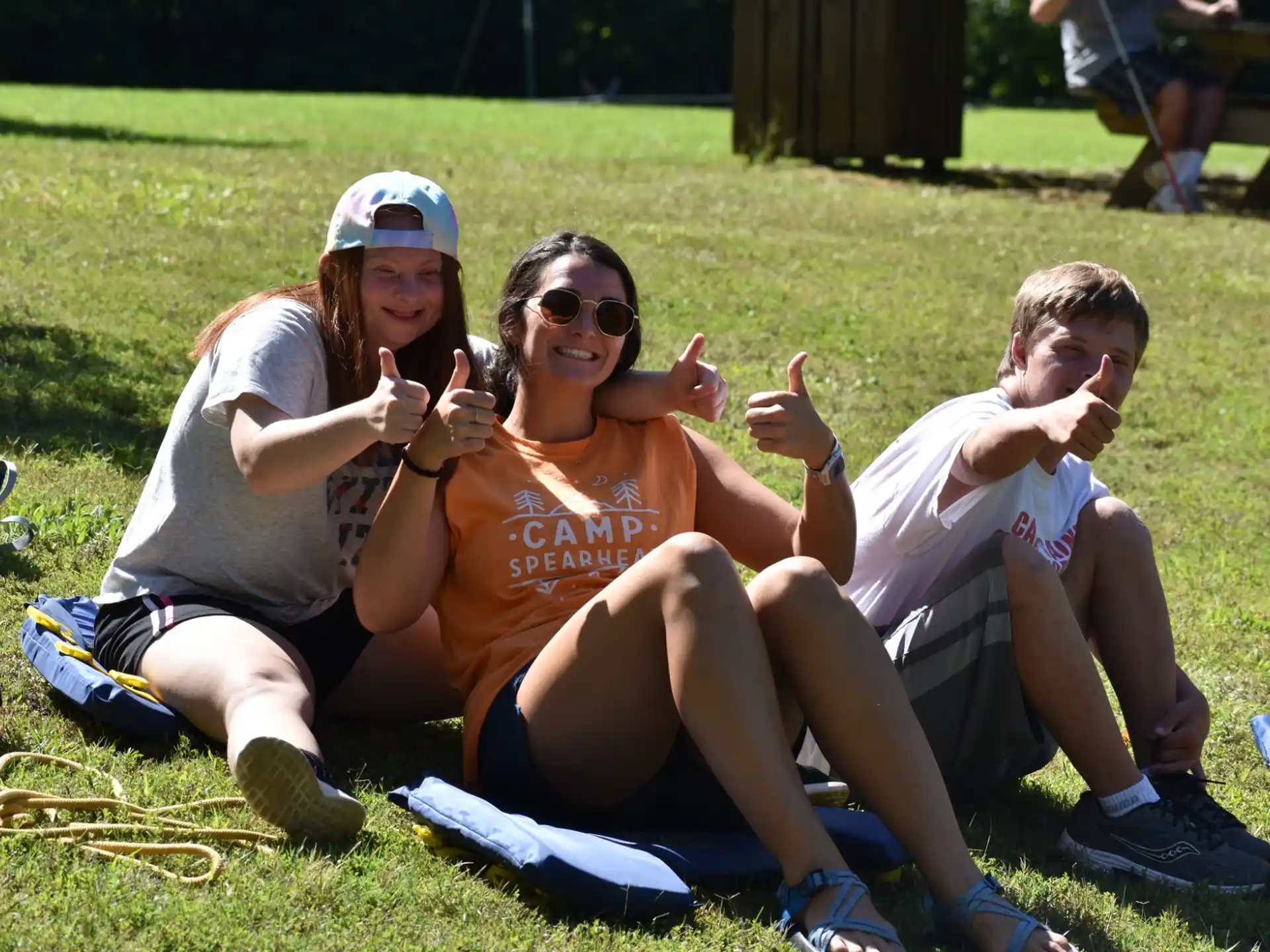 a group of people sitting on the grass posing for the camera