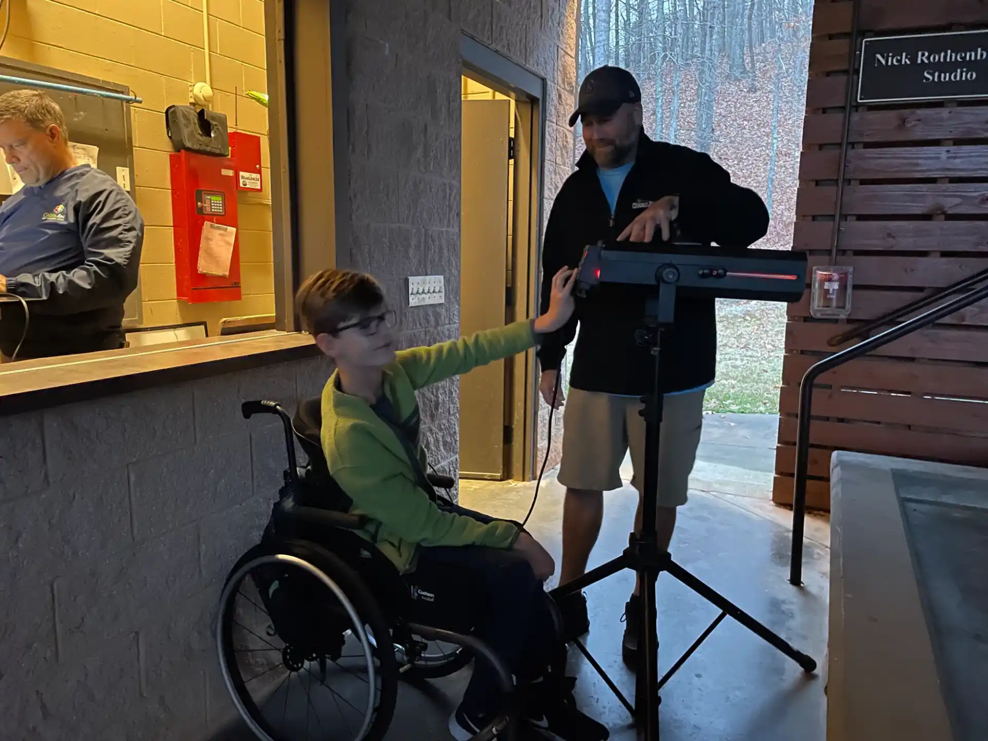 a person in a wheelchair holding a gun and a boy in a wheelchair