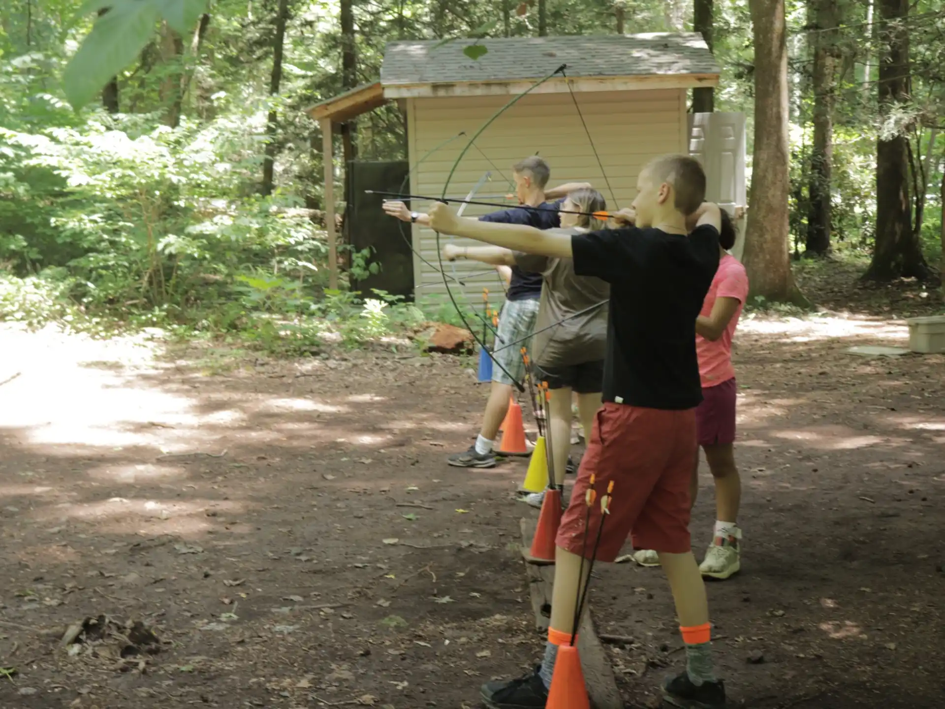 a group of people playing with a toy sword in the woods