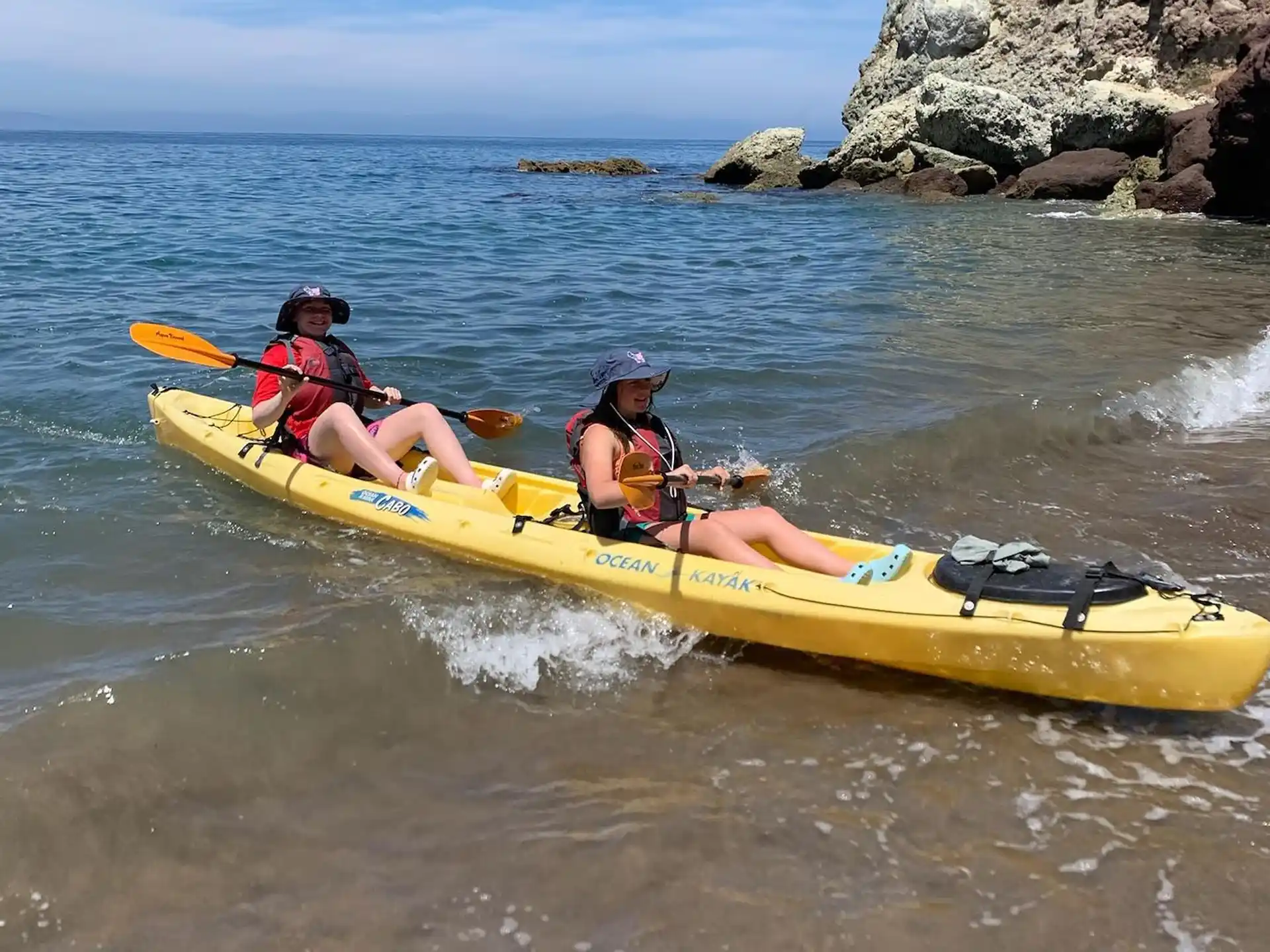 a group of people in a yellow kayak in the water