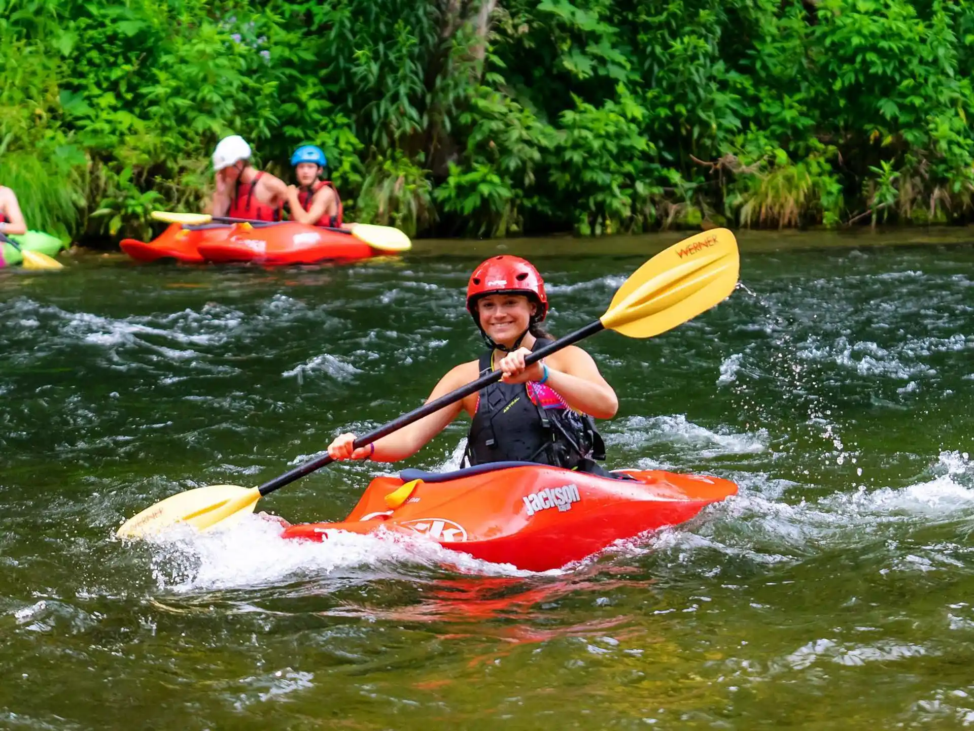 a group of people in kayaks on a river