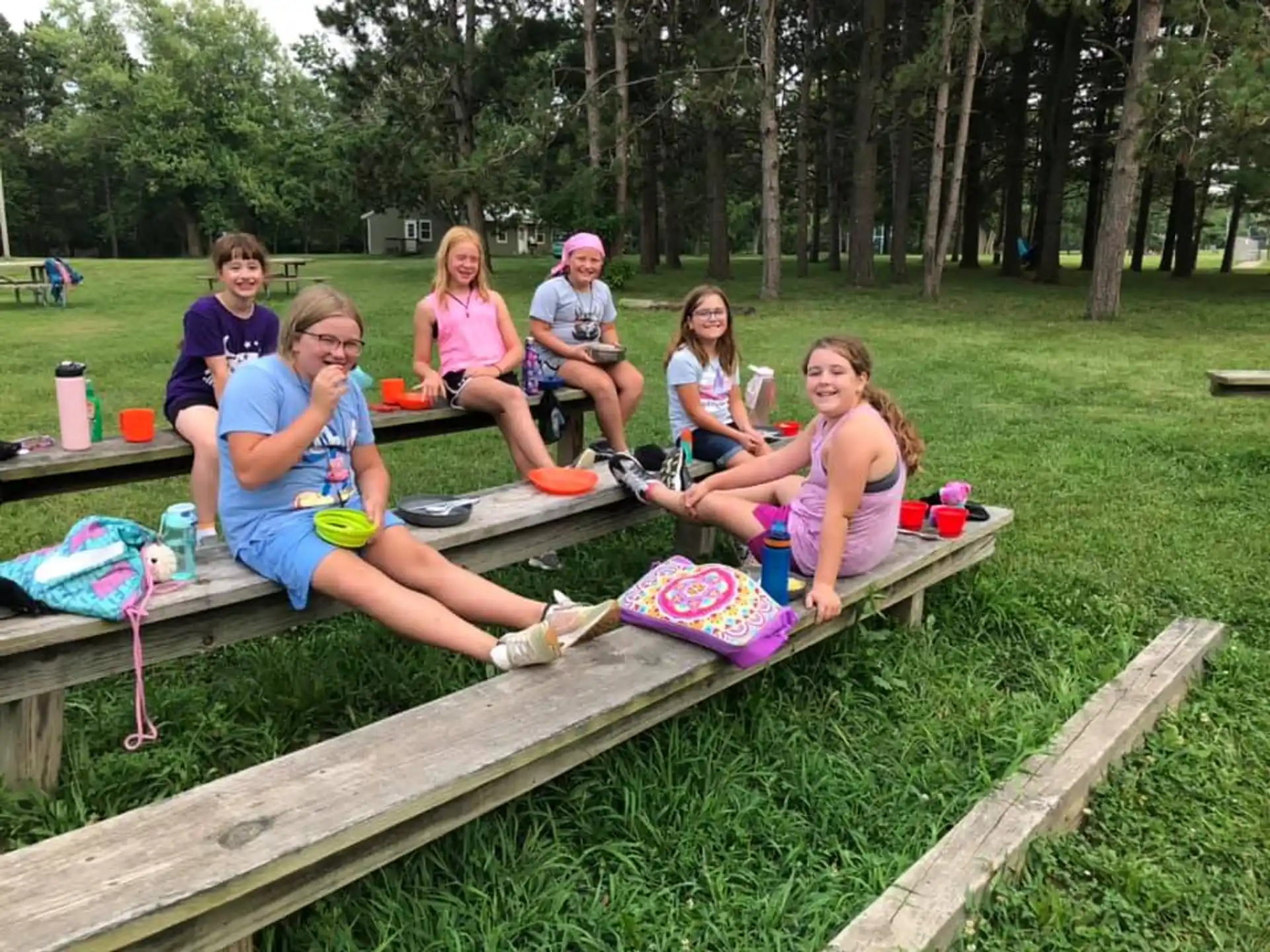 a group of people sitting on a picnic table