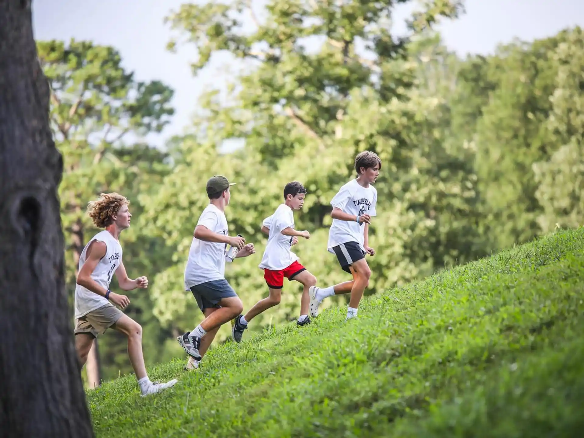 a group of people running on a grassy hill