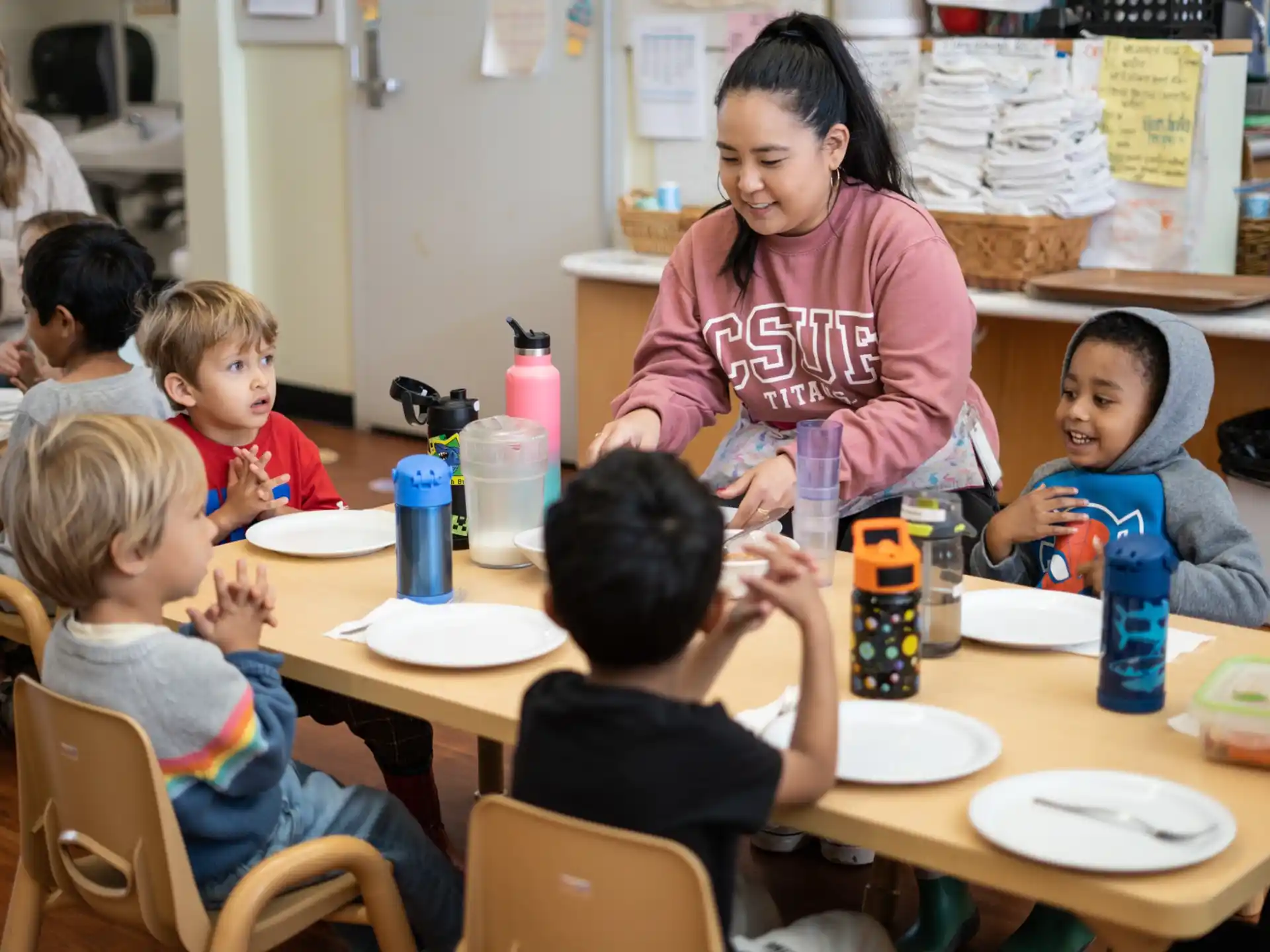 a person and several children sitting at a table